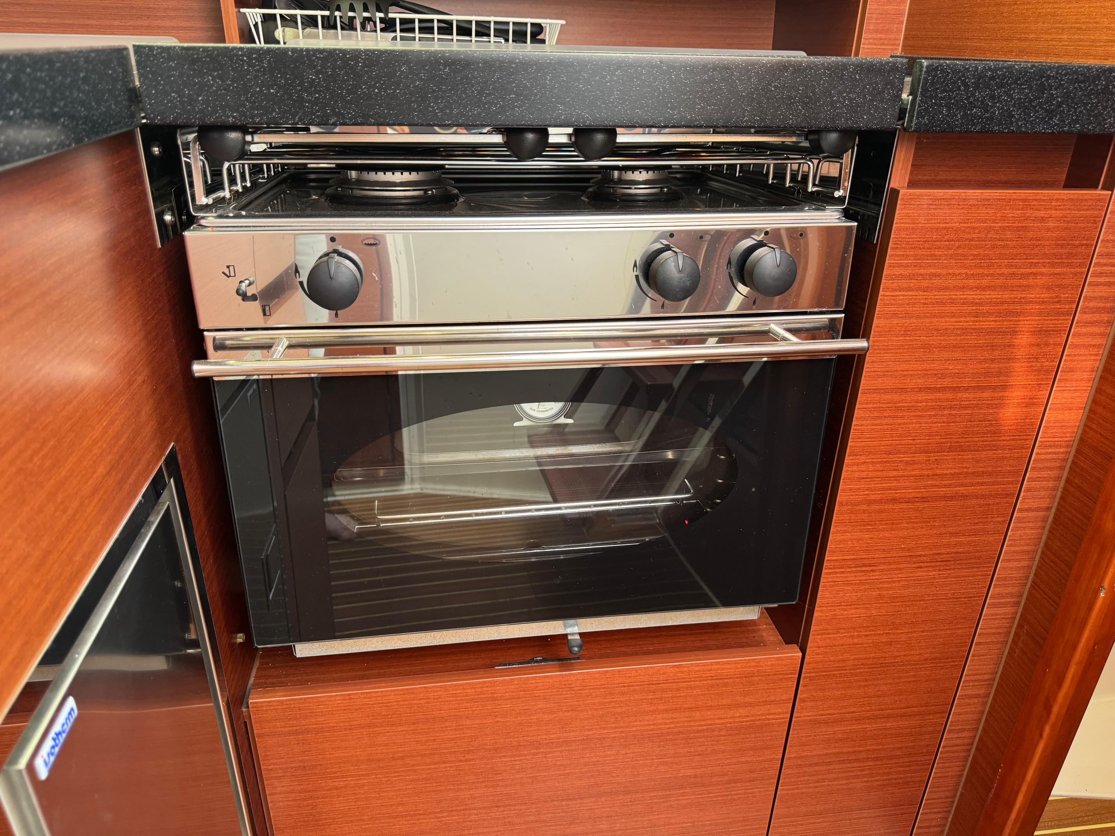 Modern kitchen oven in 2018 Hanse 348 yacht, featuring sleek wood cabinetry.