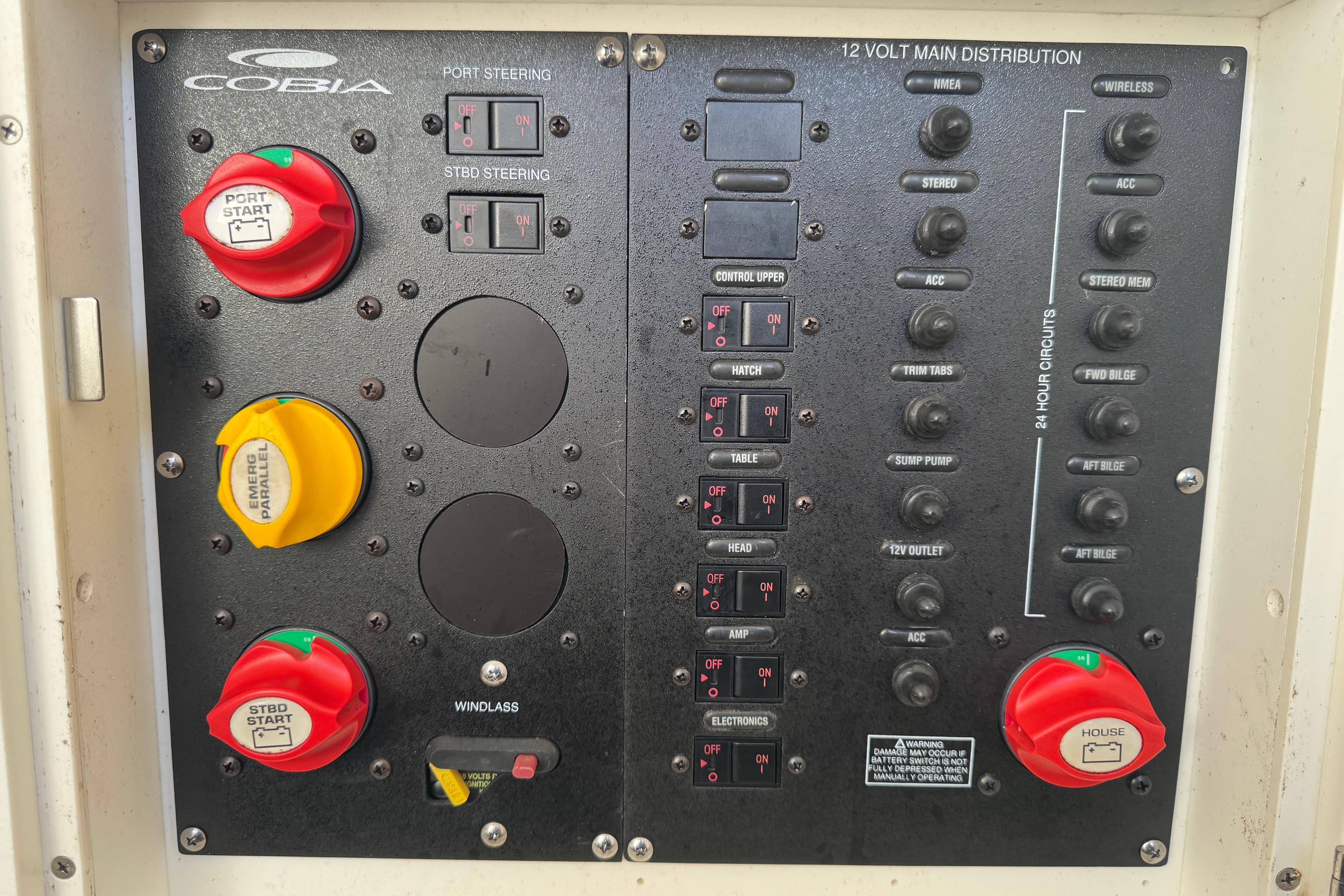 Control panel of a 2015 Cobia 344 Center Console boat with switches and labels.