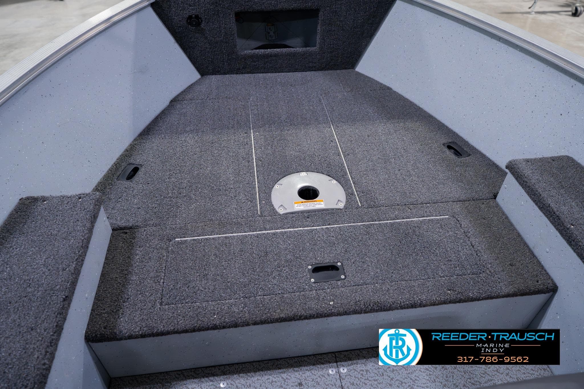 2023 Lund 1600 Fury Tiller boat interior with carpeted deck and storage compartments.