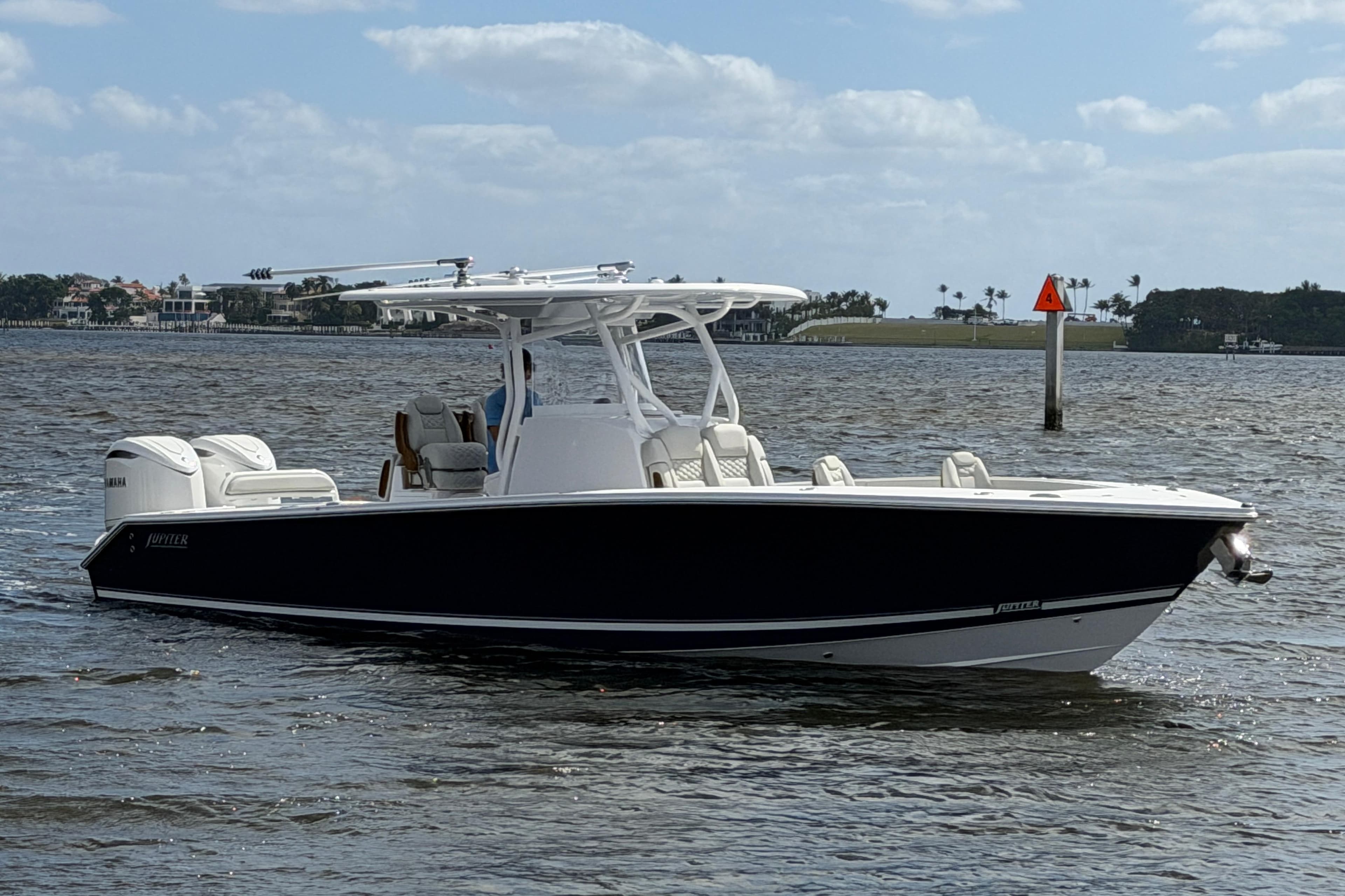 2026 Jupiter 32 boat on water, sleek design, dual engines, clear sky background.