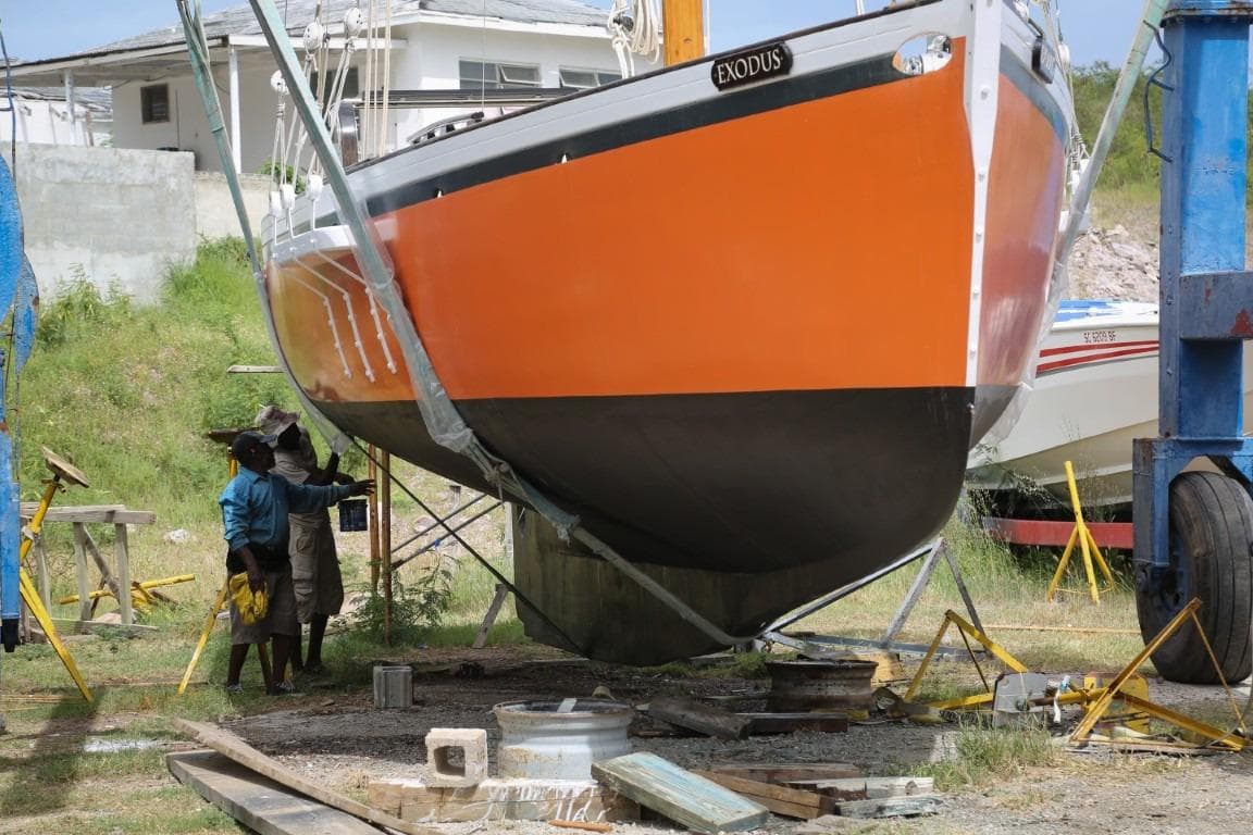 2013 Custom Carriacou Sloop 42 in dry dock, vibrant orange hull, maintenance underway.