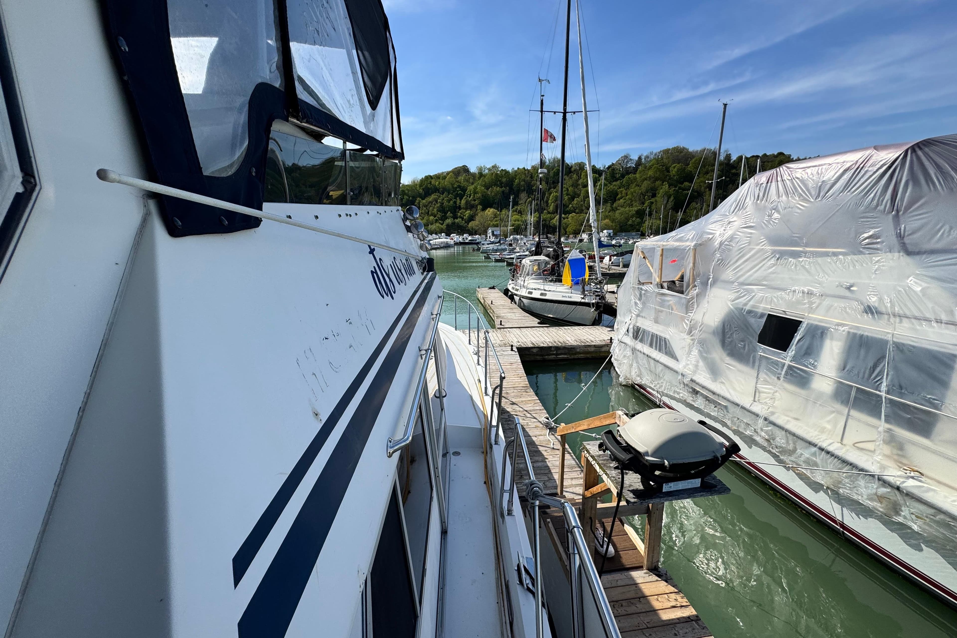 1989 Hi-Star 42 Sundeck yacht docked at marina, sunny day, covered boat nearby.