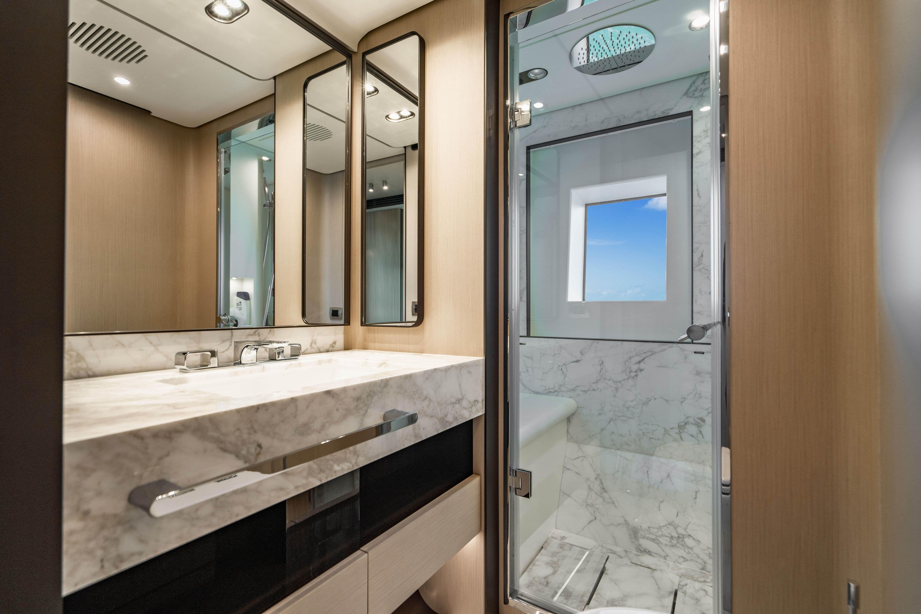 Luxurious 2023 Azimut yacht bathroom with marble sink and modern shower.