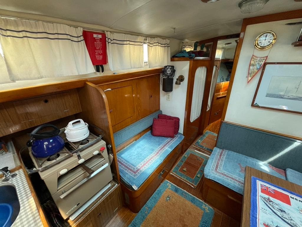 Interior of a 1973 Camper & Nicholsons 38 yacht with cozy seating and kitchen area.