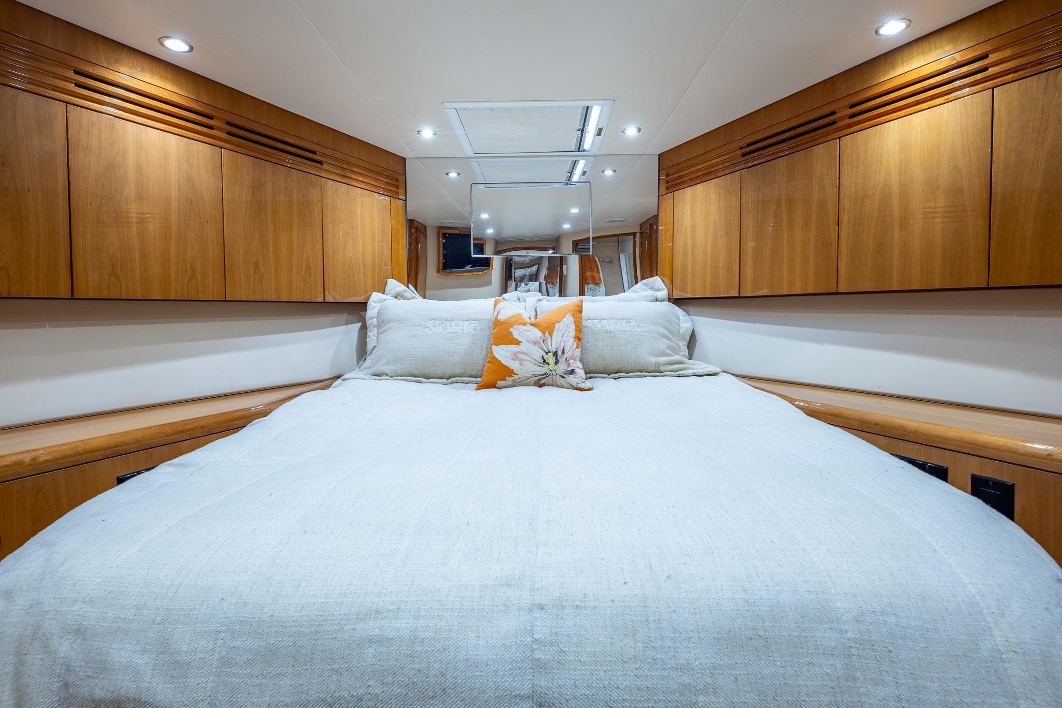 Luxurious bedroom interior of 2009 Hatteras 64 Motor Yacht with wood cabinetry.