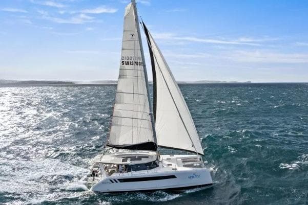 2026 Seawind 1370 catamaran sailing on open ocean under clear blue sky.