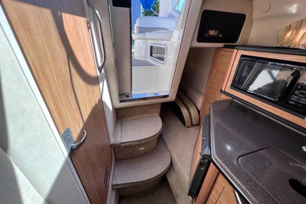 Interior of a 2006 Searay 260 boat, featuring stairs and a compact kitchen area.