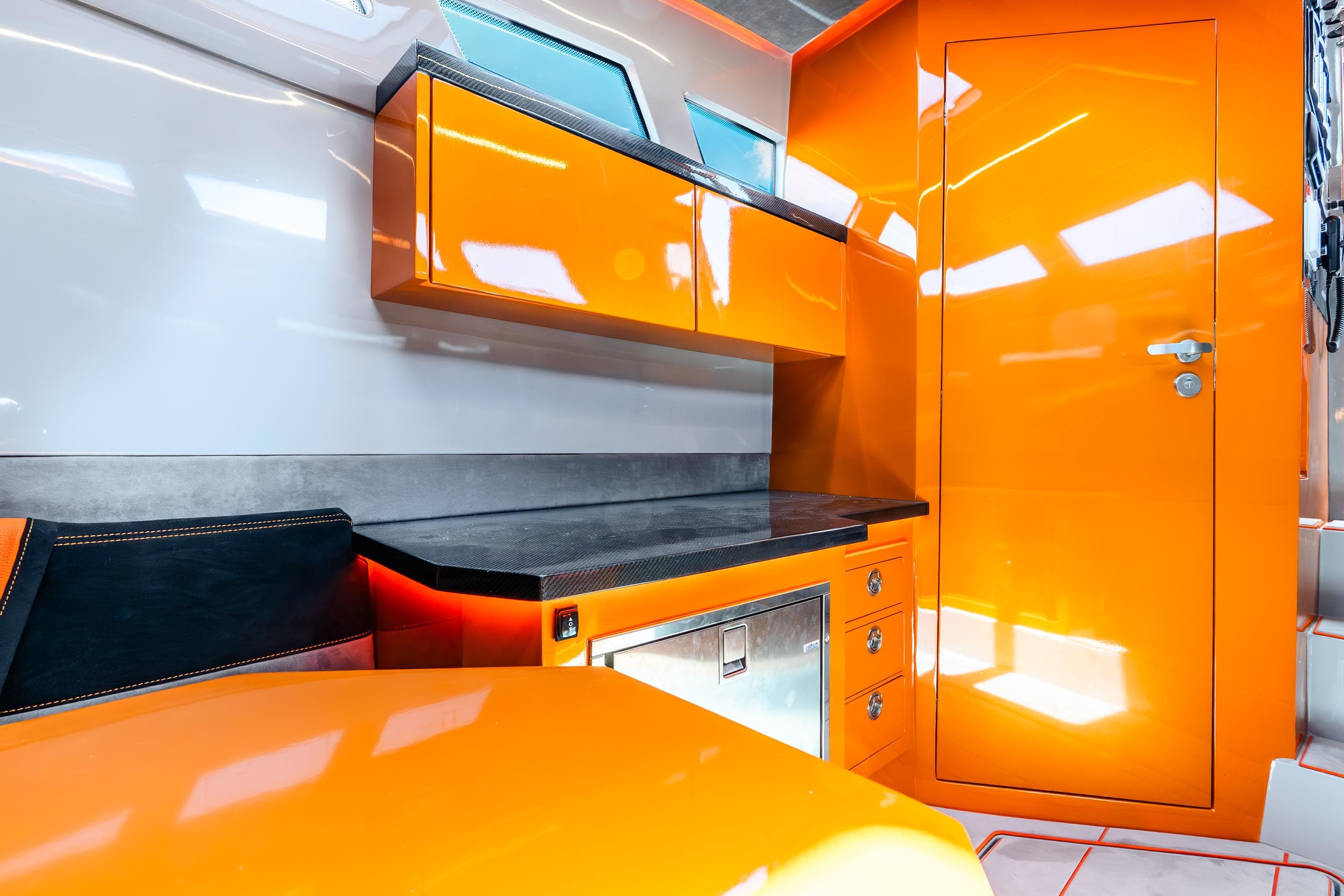Modern interior of 2025 Statement 44 GRTS boat with vibrant orange cabinetry.