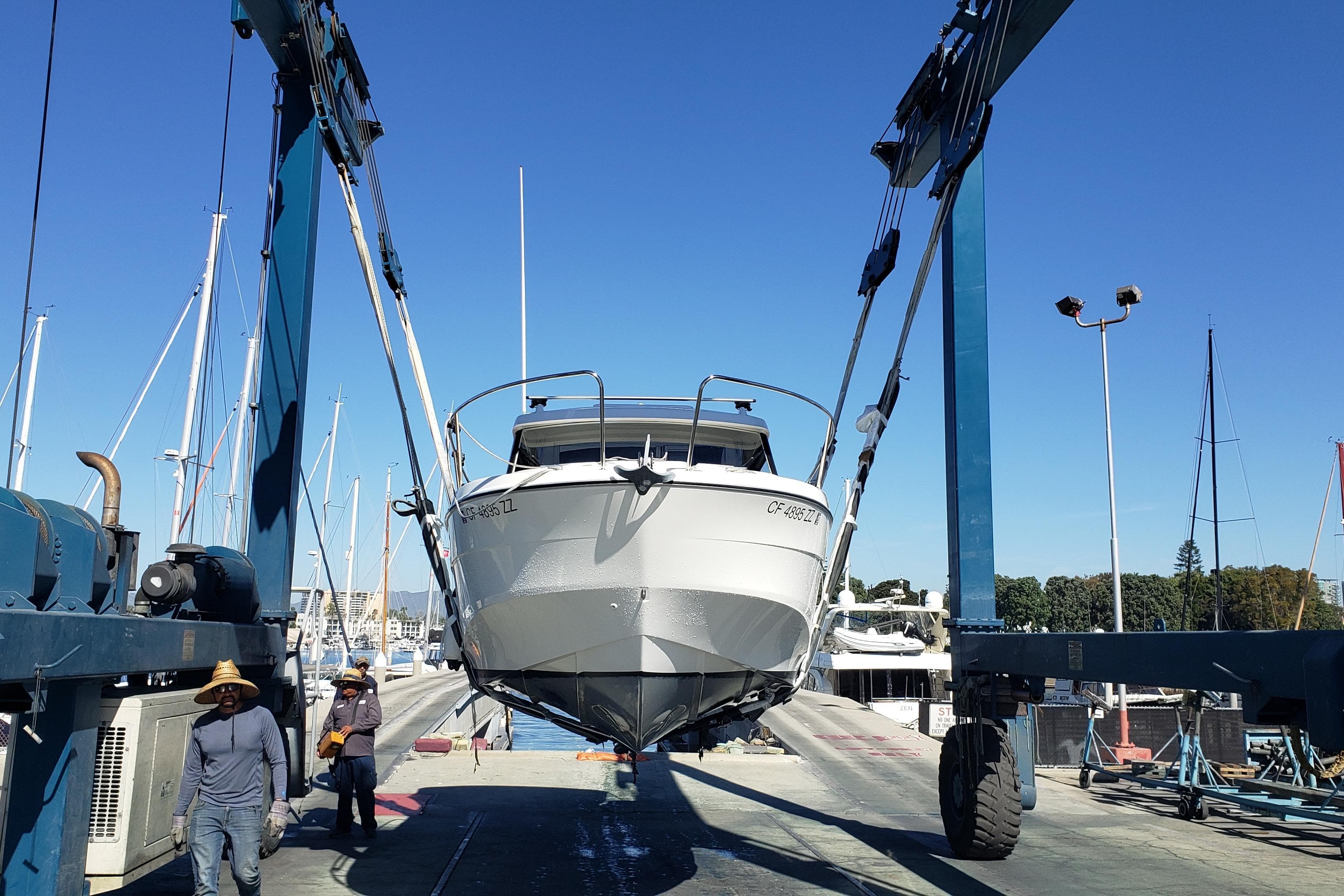 2019 Beneteau Antares 23 boat lifted at marina with blue sky background.
