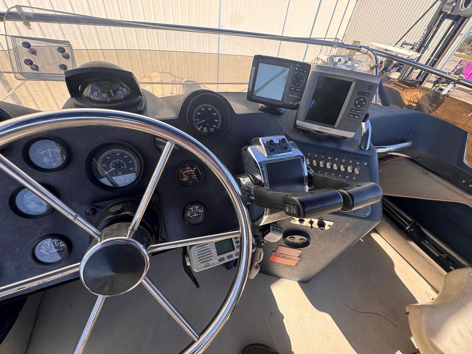1988 Sea Ray 265 Sedan Bridge helm with steering wheel, gauges, and navigation equipment.