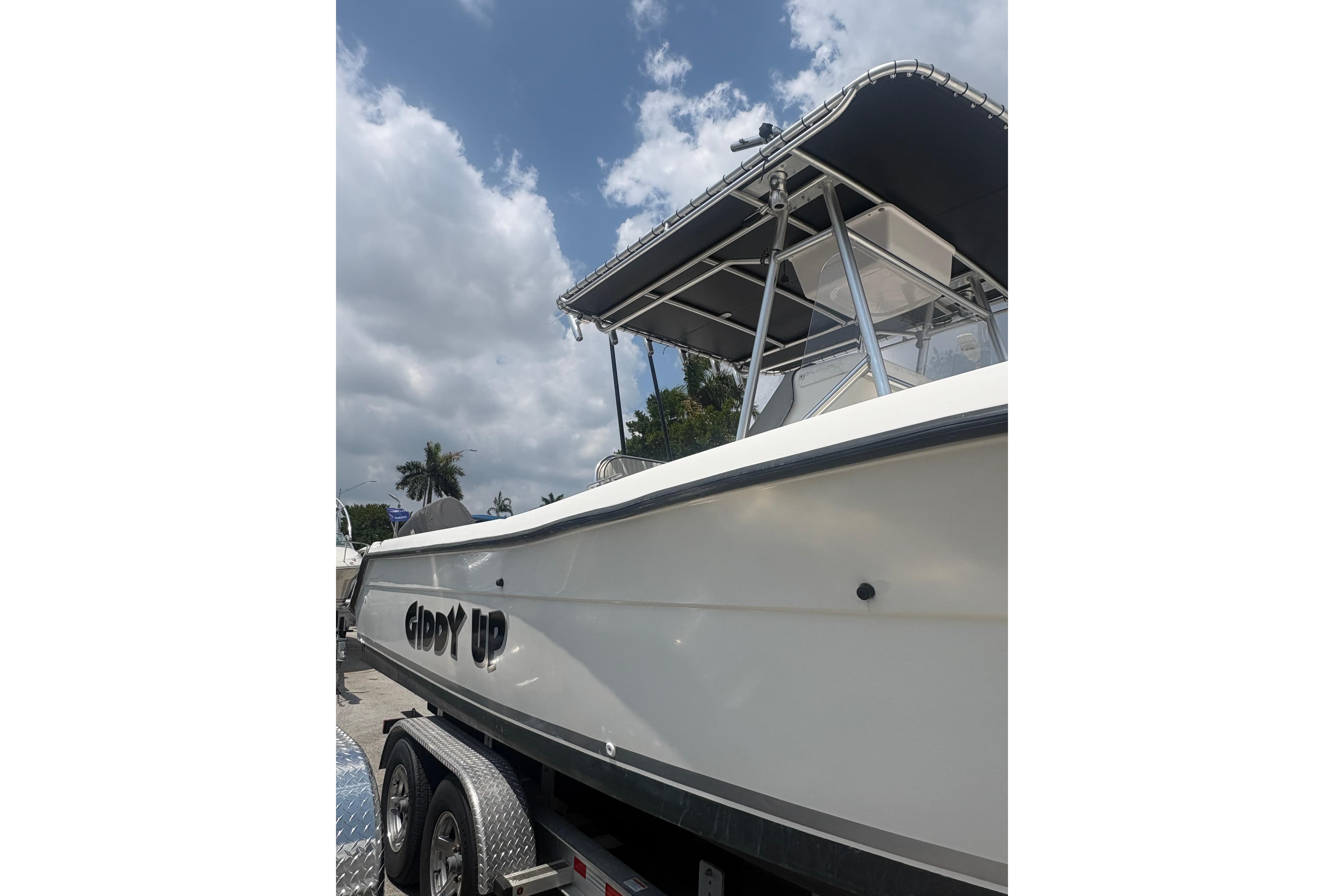 1998 Pursuit 2870 Center Console boat on trailer under cloudy sky.