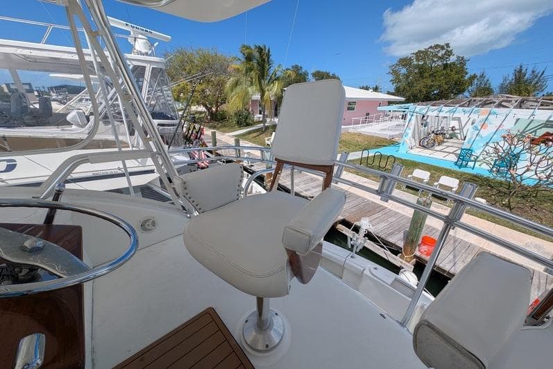 Captain's chair on 2005 Egg Harbor 43 SportYacht, docked with clear skies and palm trees.