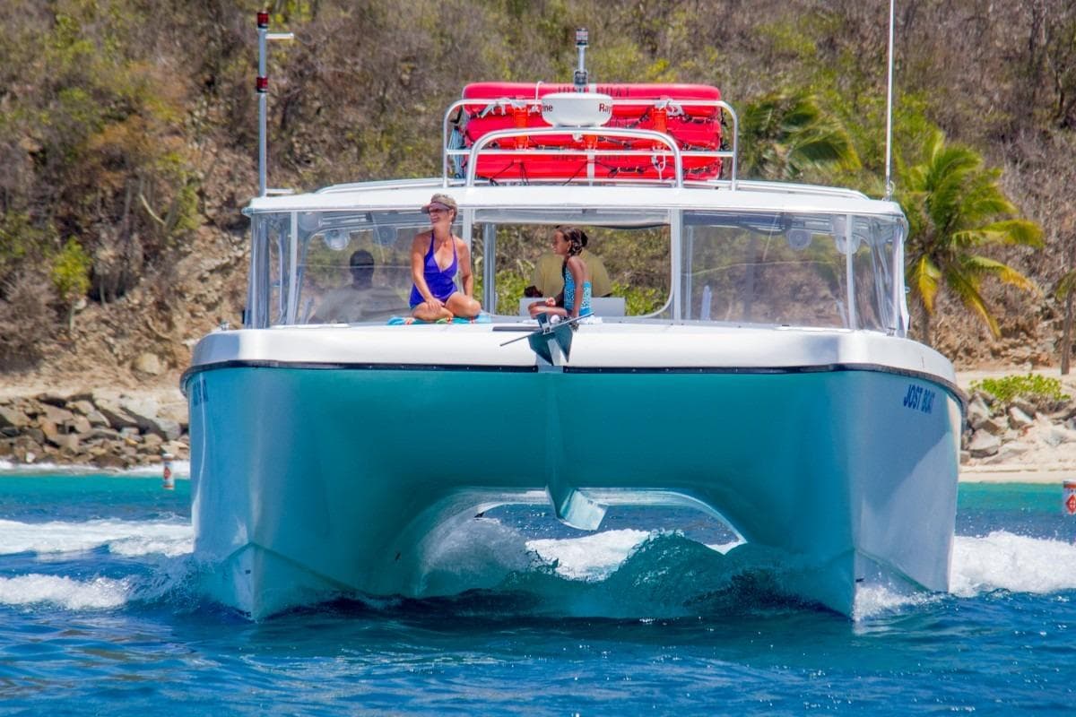 2014 Cooper Marine Offshore 46 Molds catamaran cruising near tropical shoreline.