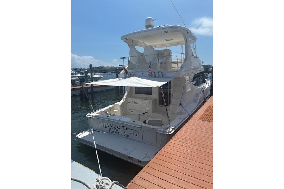 2004 Silverton 48 Convertible yacht docked, featuring spacious deck and elegant design.