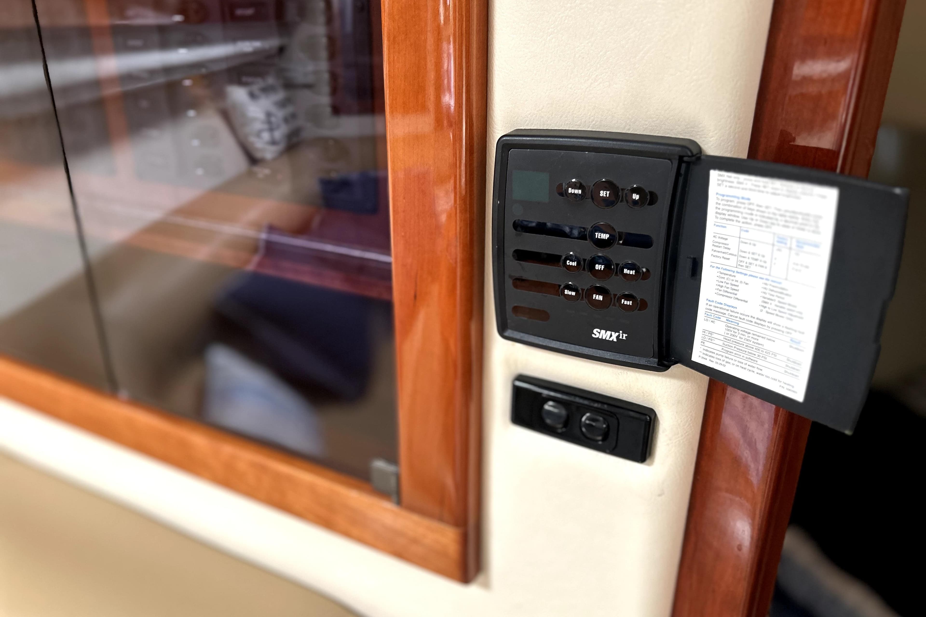 Control panel inside 2004 Wellcraft 47 Excalibur boat, featuring wood trim and digital display.