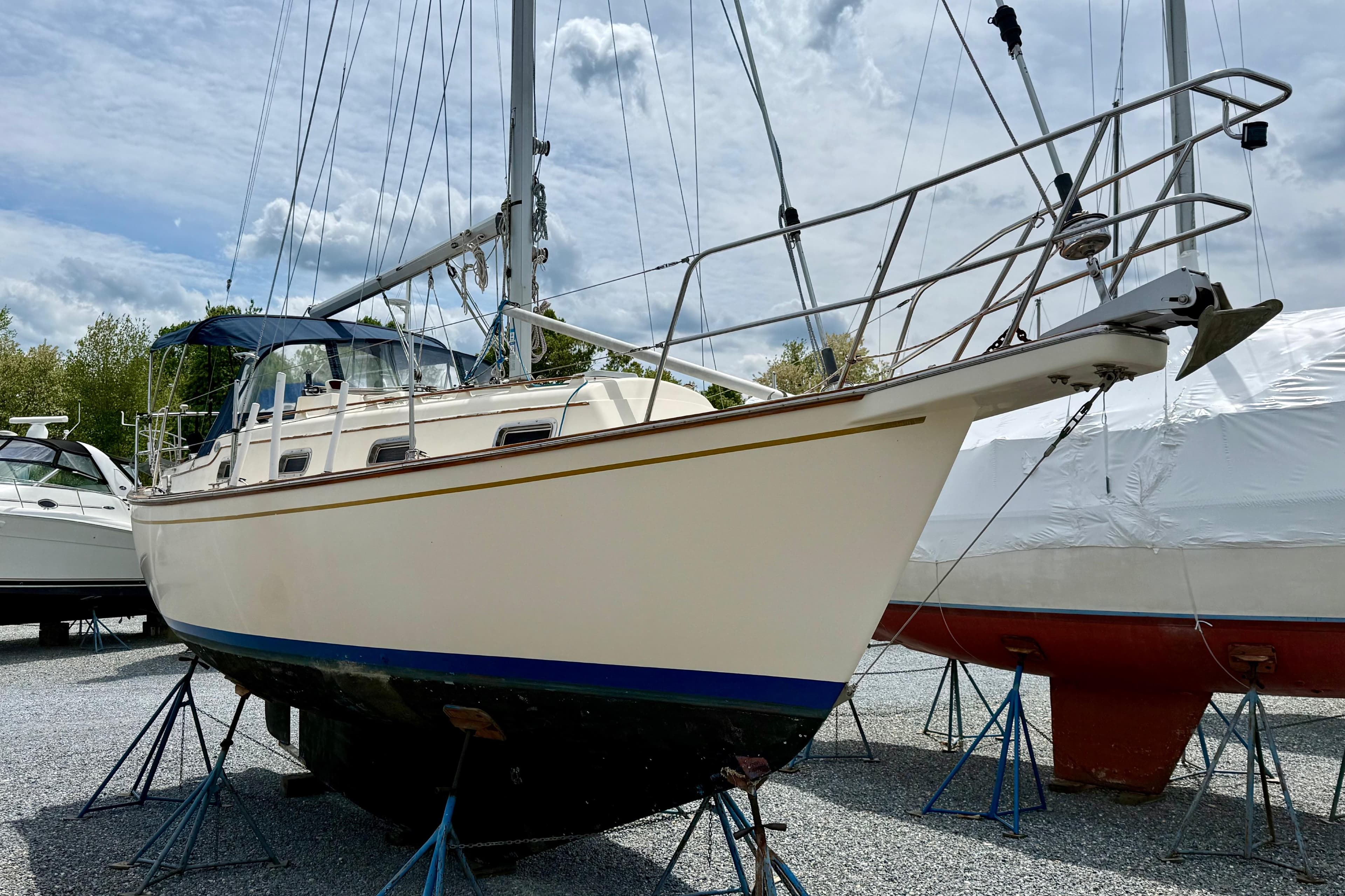 1992 Island Packet 29 sailboat on stands, displayed outdoors under cloudy sky.