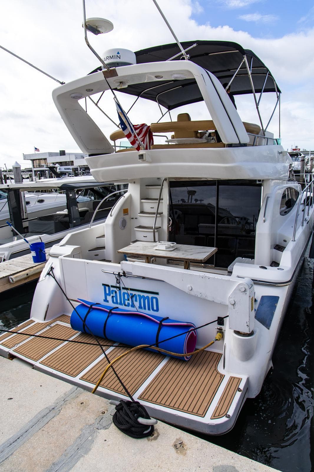 Luxury 2002 Dyna 50 yacht docked, featuring spacious deck and modern amenities.