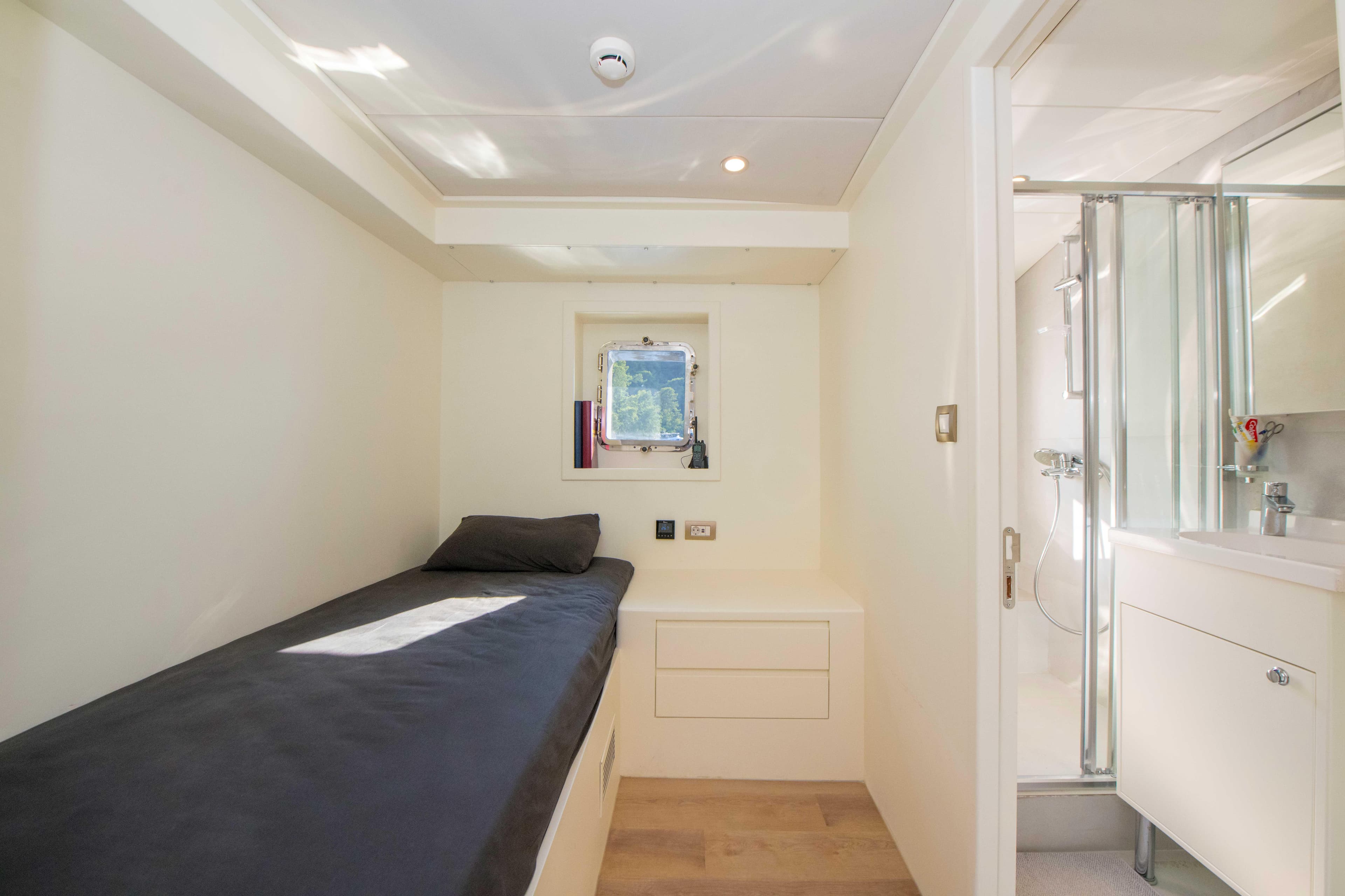 2023 Custom Motorsailer 41M cabin with single bed, window, and ensuite bathroom.