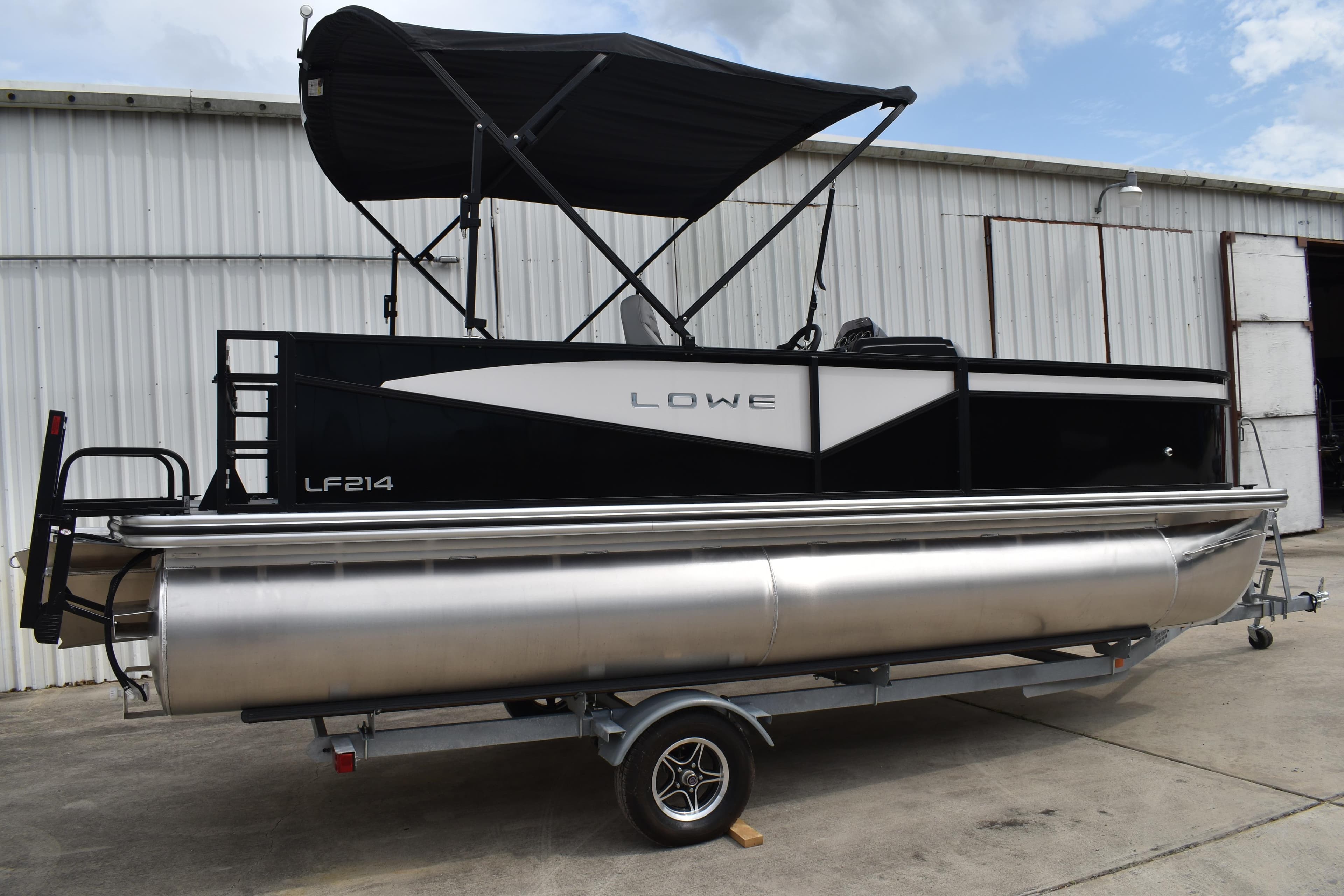 2026 Lowe LF 214 pontoon boat on trailer, black and silver design, parked outdoors.