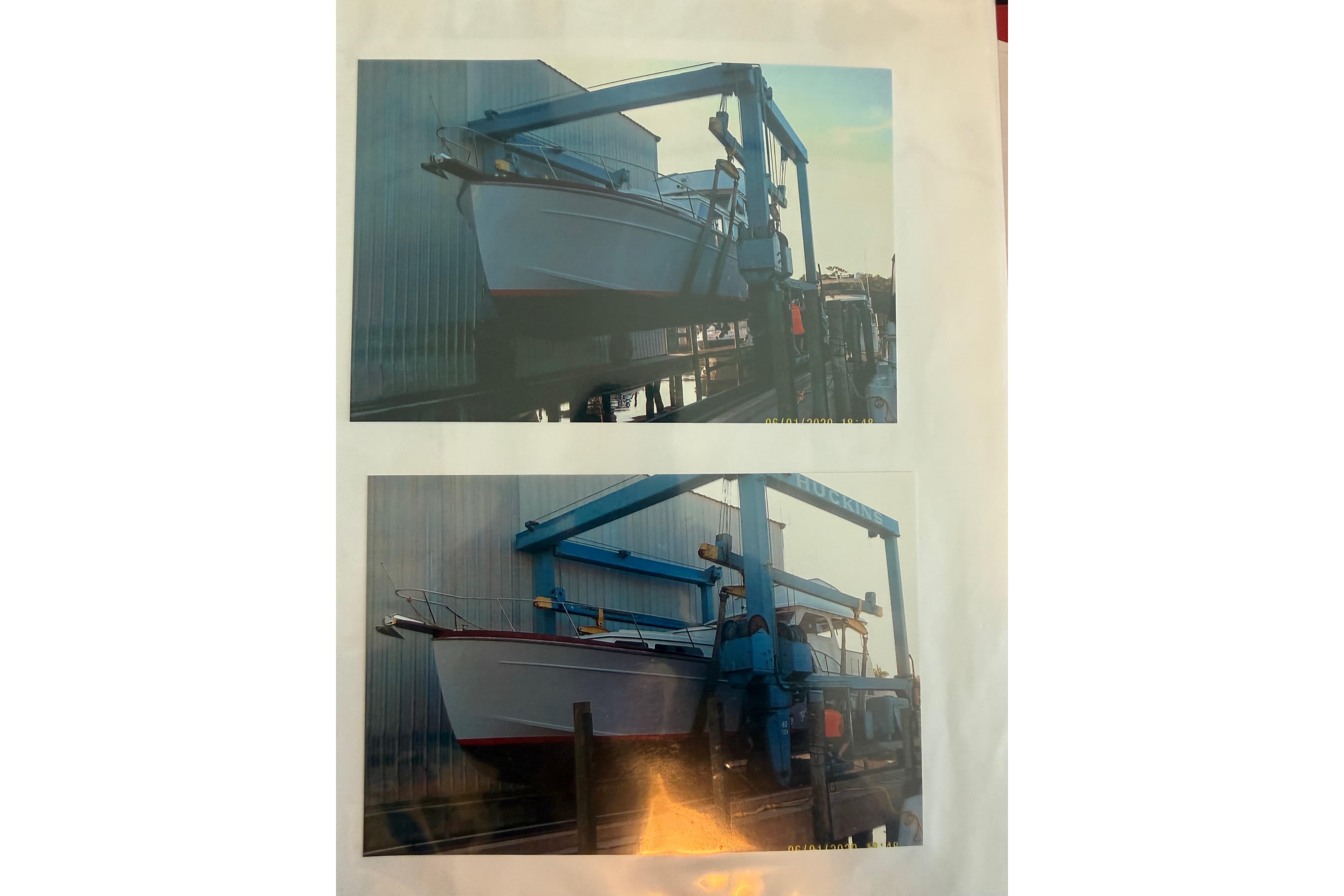 2006 Huckins Atlantic 44 yacht in dry dock, supported by a blue boat lift.