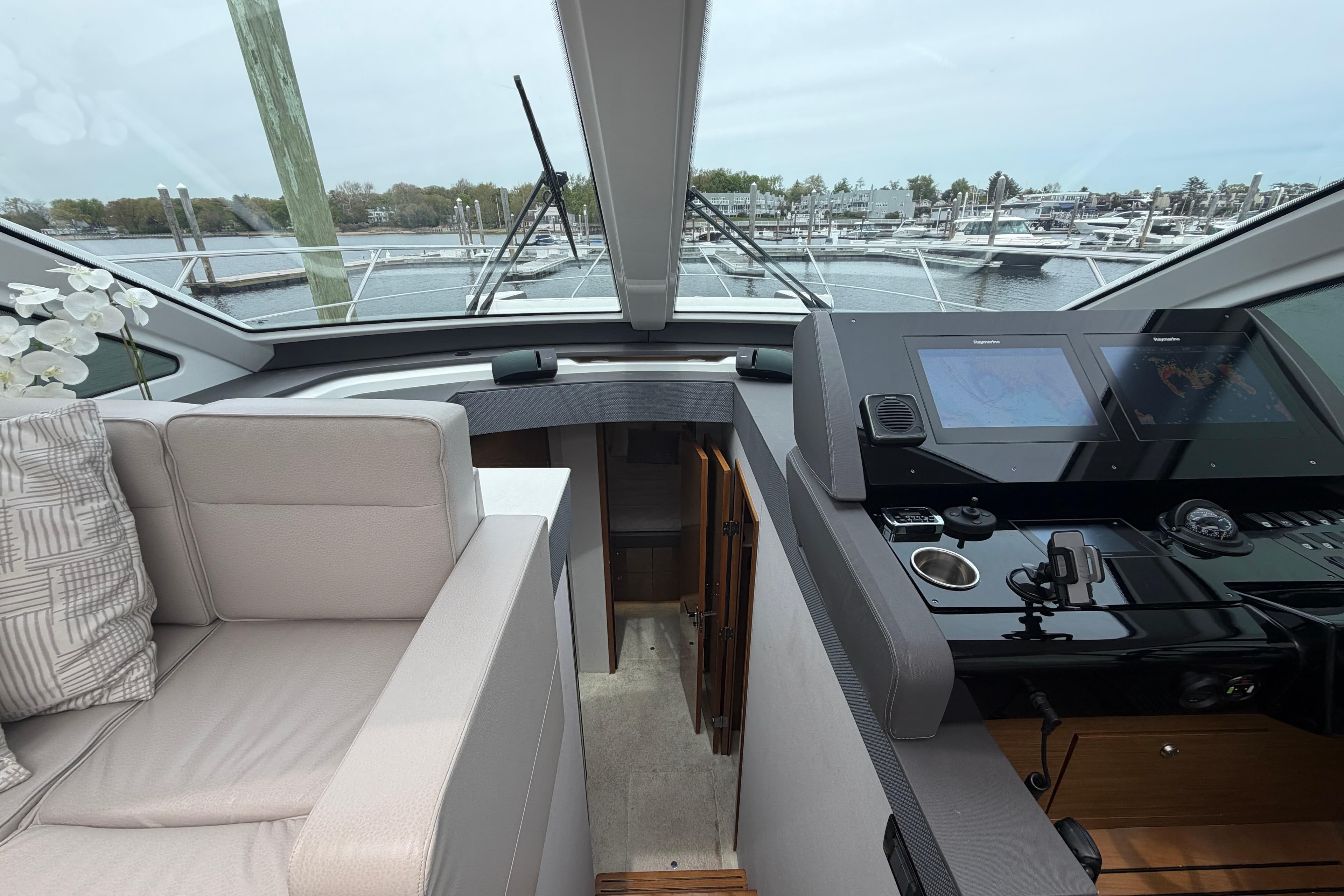 Interior view of 2018 Cruisers Yachts 50 Cantius helm with modern navigation equipment.