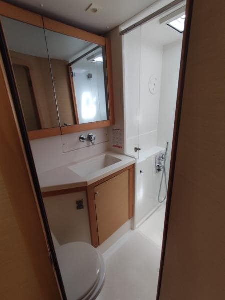 Modern bathroom in 2017 Lagoon 450S yacht with sink, mirror, and shower.