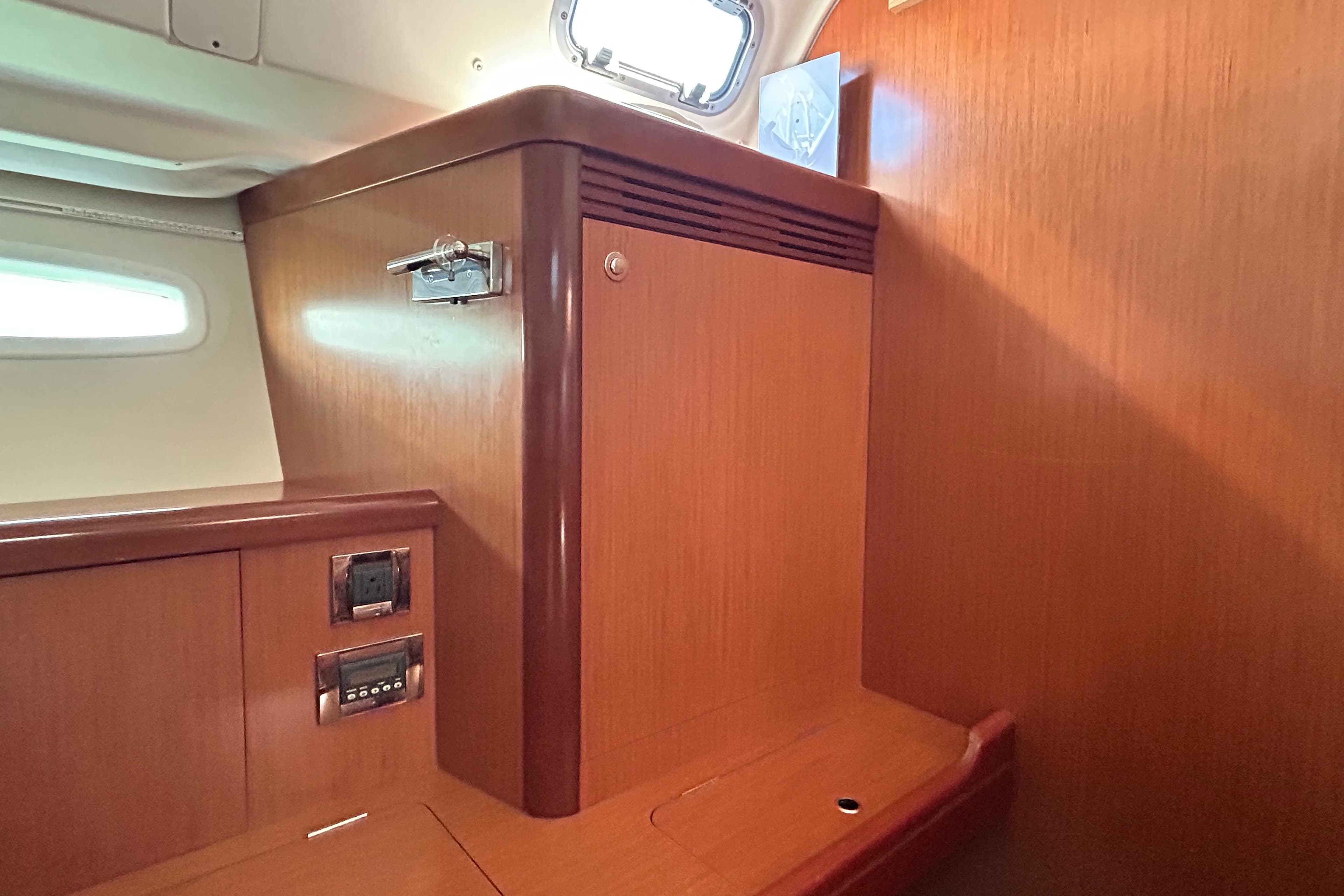 Interior cabin of 2008 Beneteau Oceanis 46 yacht with wooden cabinetry and porthole.
