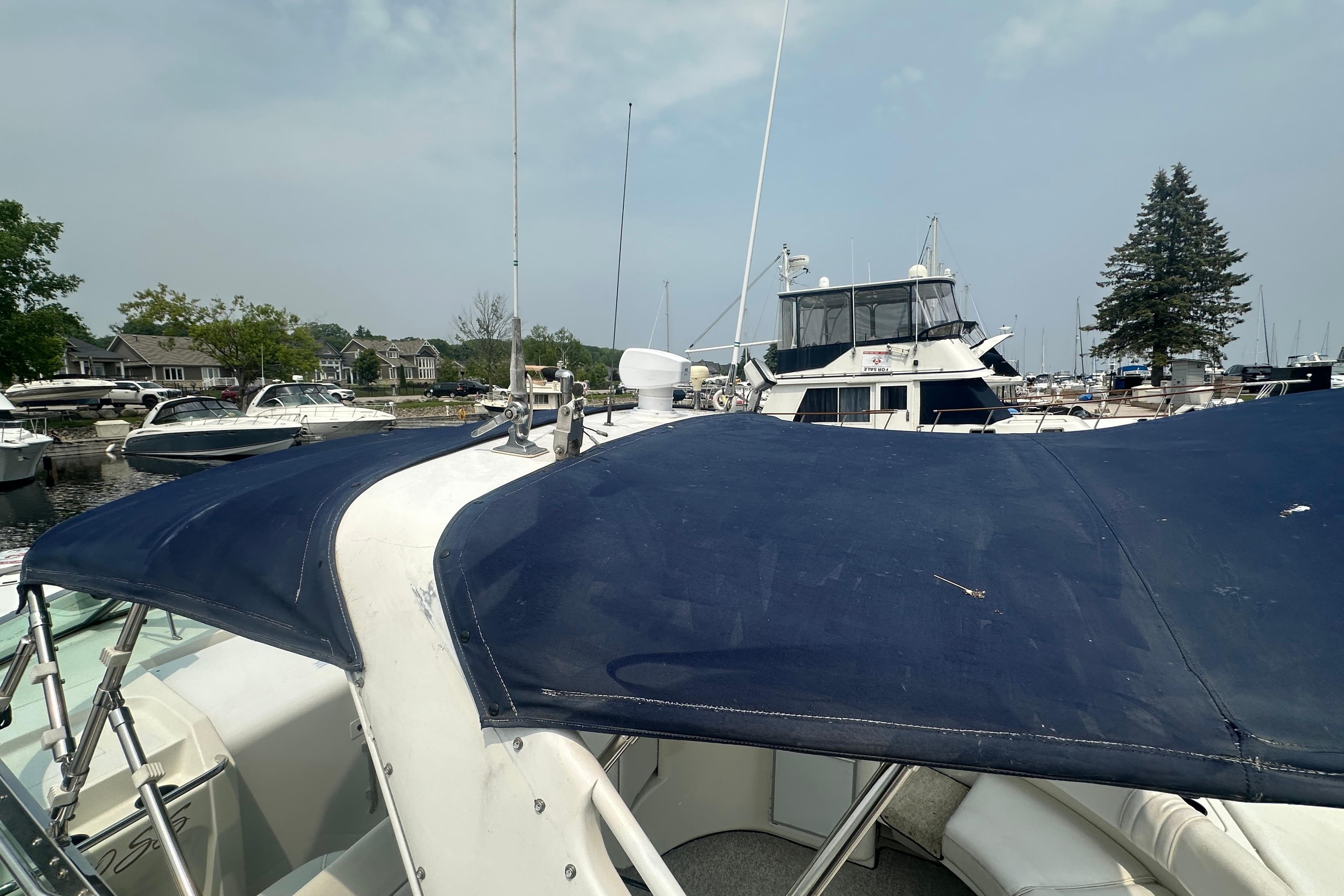1995 Sea Ray 380 Sun Sport boat docked at marina with blue canopy.