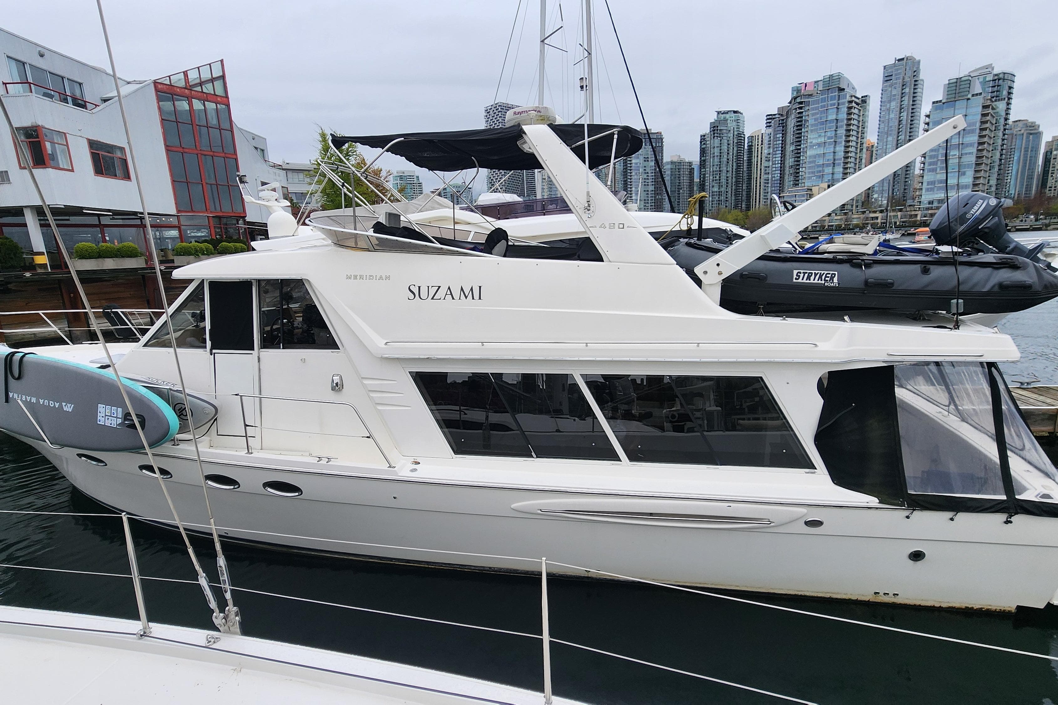 2003 Meridian 490 Pilothouse yacht docked in urban marina with city skyline backdrop.