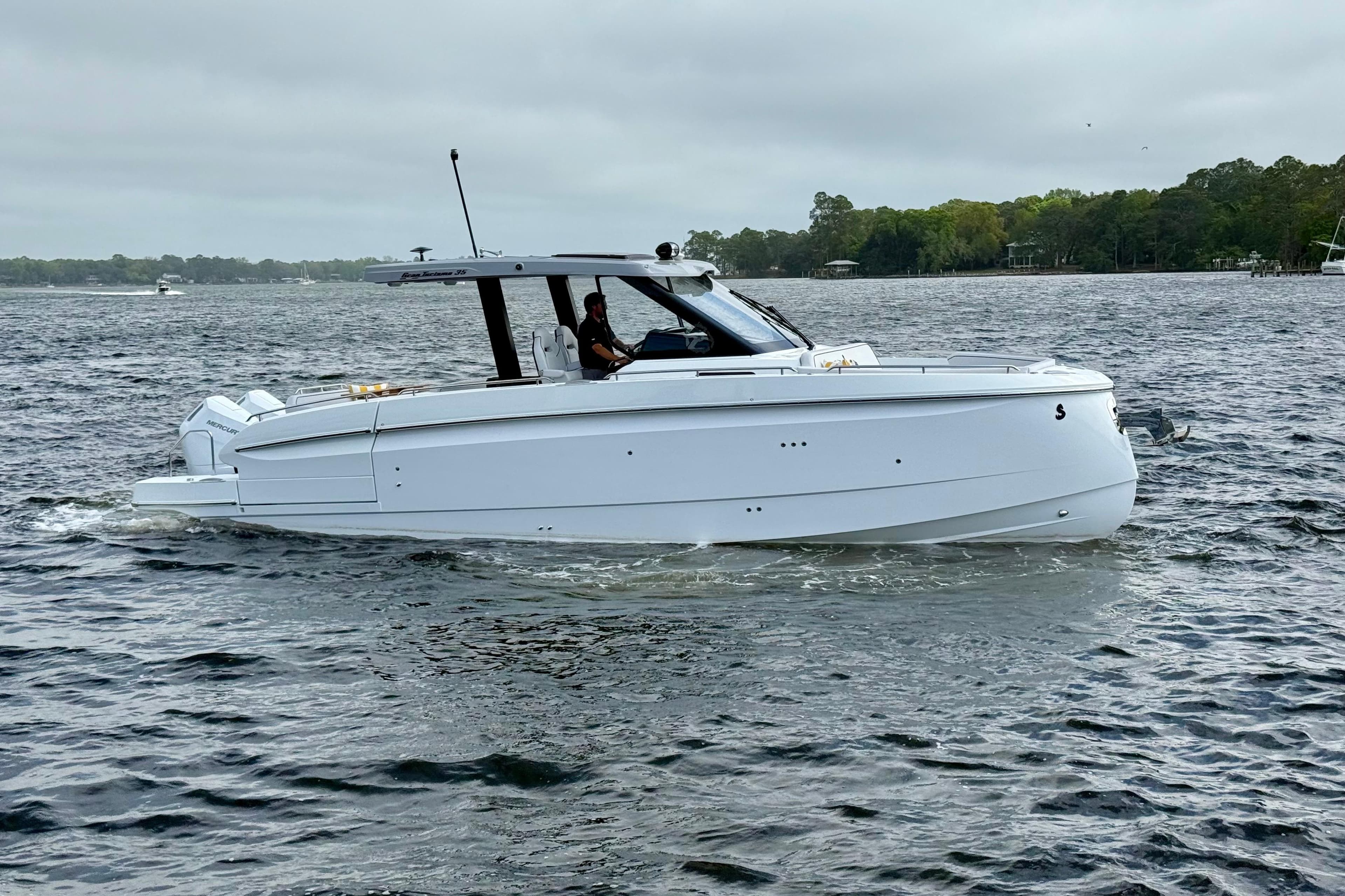 2026 Beneteau Gran Turismo 35 cruising on a serene lake under cloudy skies.