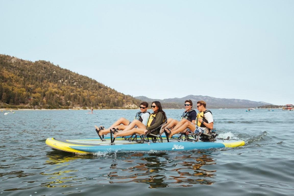 Four people enjoying a ride on a 2025 Hobie iTrek Fiesta pedal kayak.