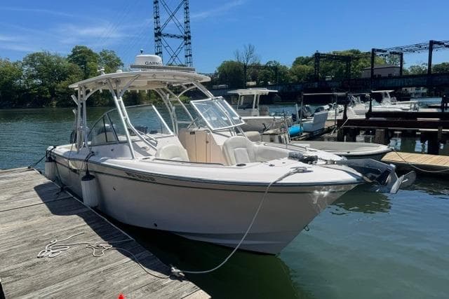 2012 Grady-White Freedom 275 boat docked at a marina under clear blue skies.