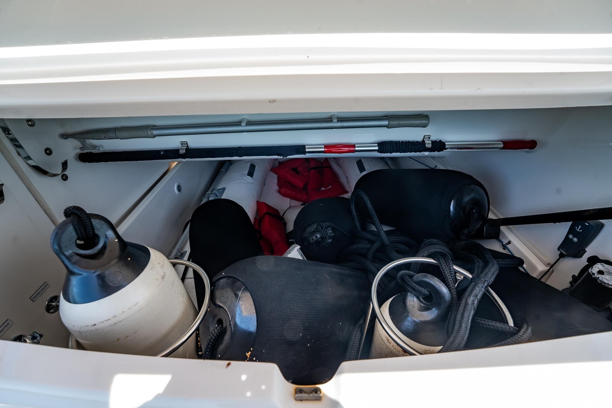 Storage compartment of 2016 Riviera 5000 Sport Yacht with fenders and ropes.