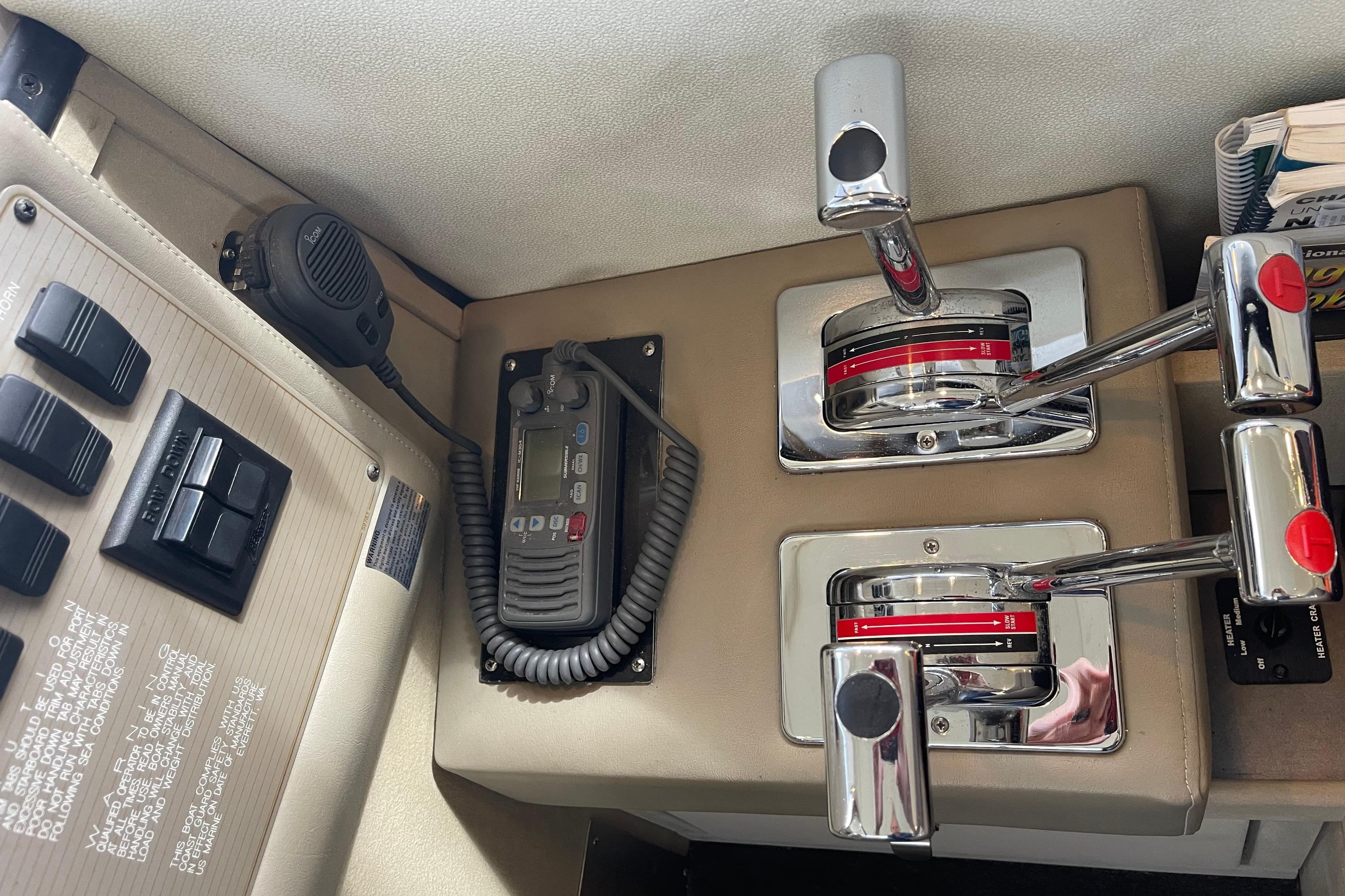 Control panel of a 1996 Bayliner 3255 Avanti boat with throttle levers and radio.