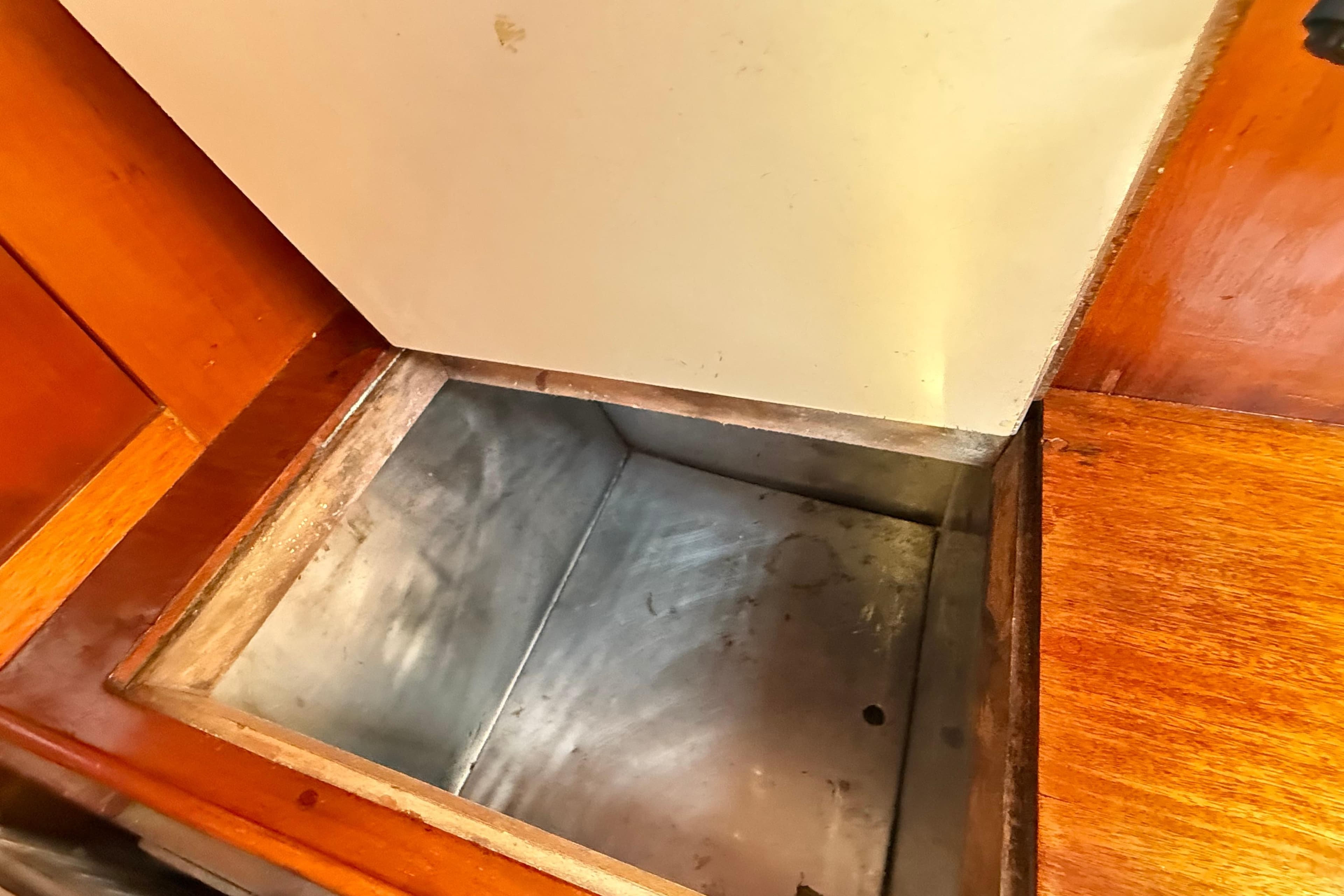 Open storage compartment in 1986 Vindo 45 boat interior with wooden finish.