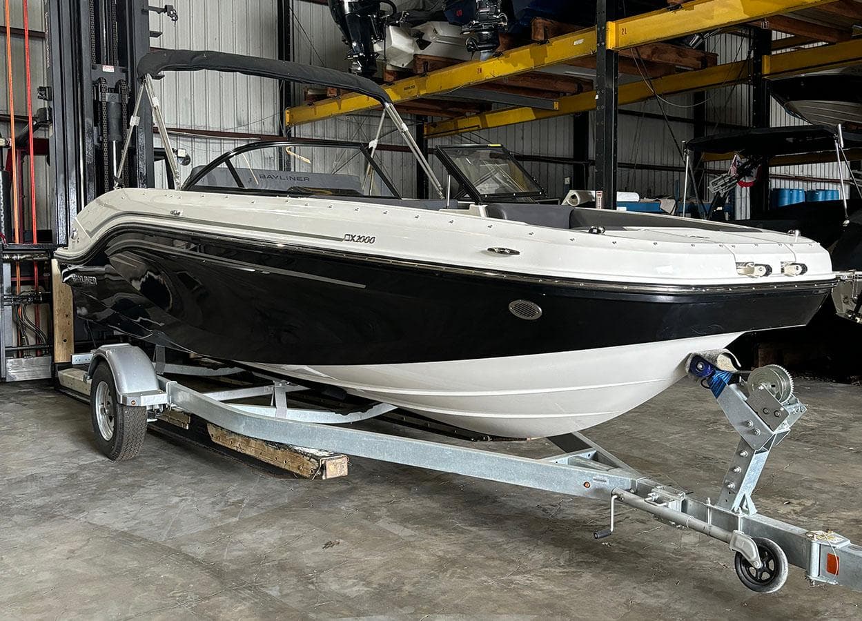 2024 Bayliner DX 2000 boat on a trailer in a storage facility.