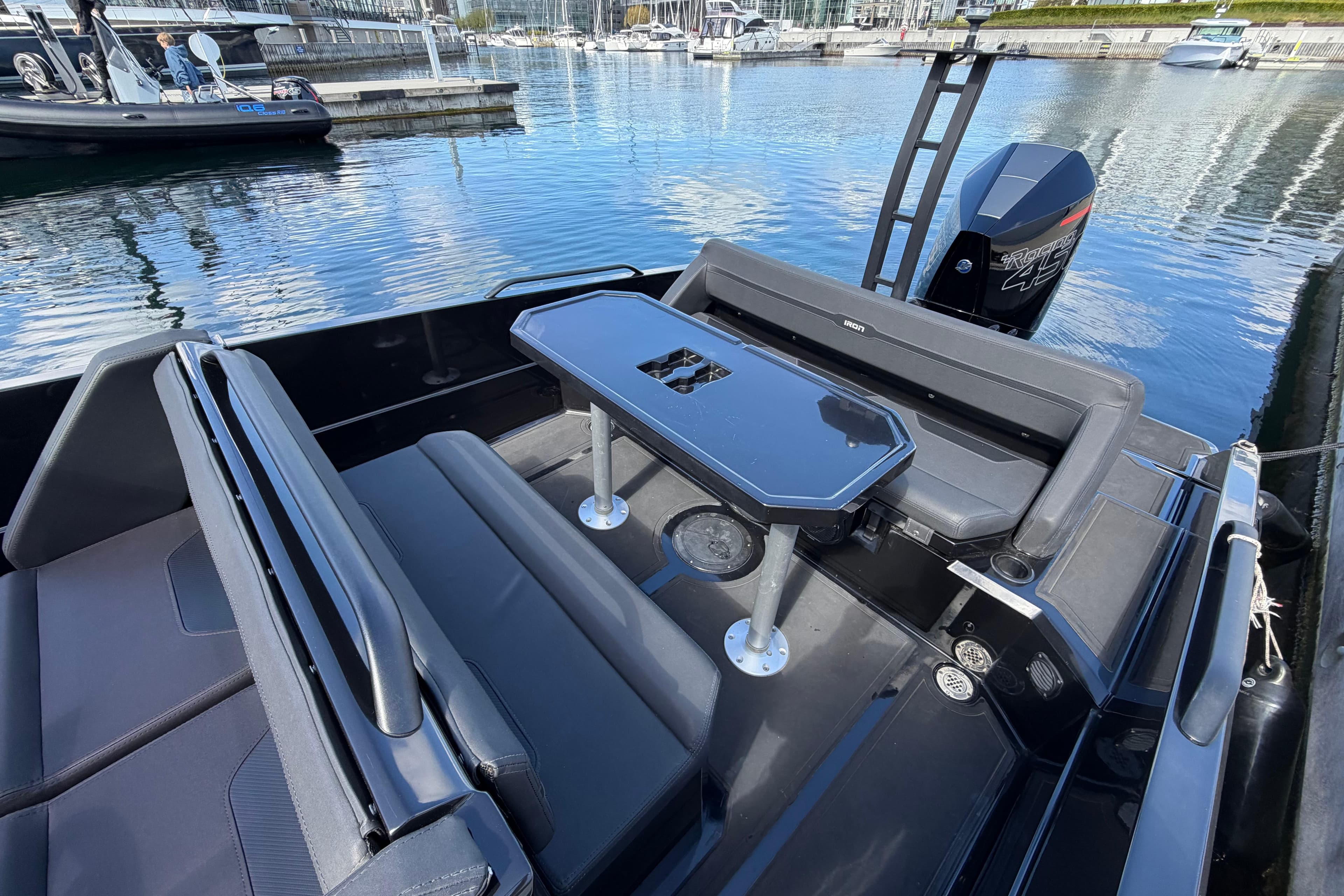 Modern Iron 827R boat interior with sleek seating and table, docked at a marina, 2022 model.