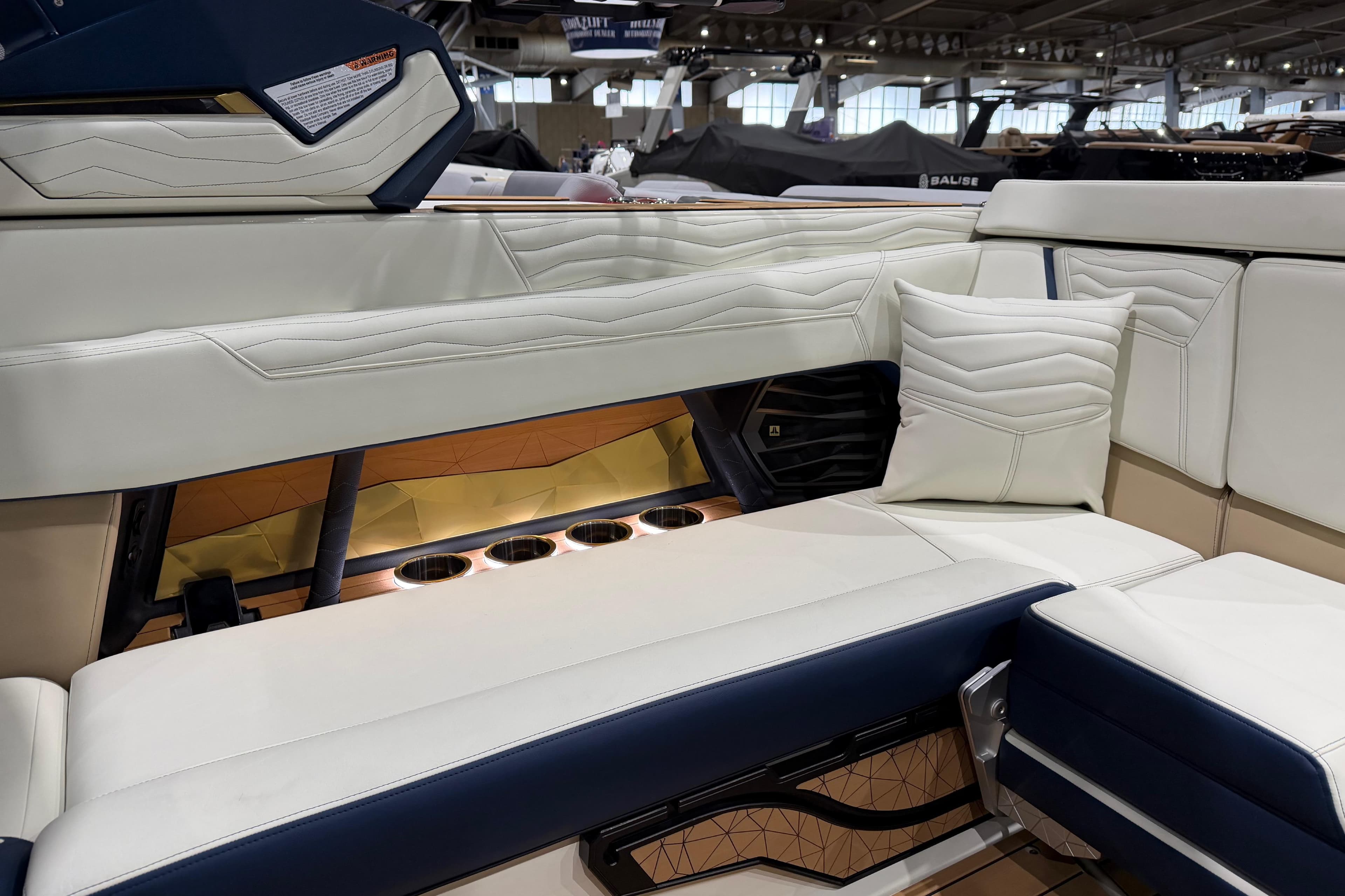 Luxurious interior of 2026 Nautique Super Air Nautique G25 with plush seating and cup holders.