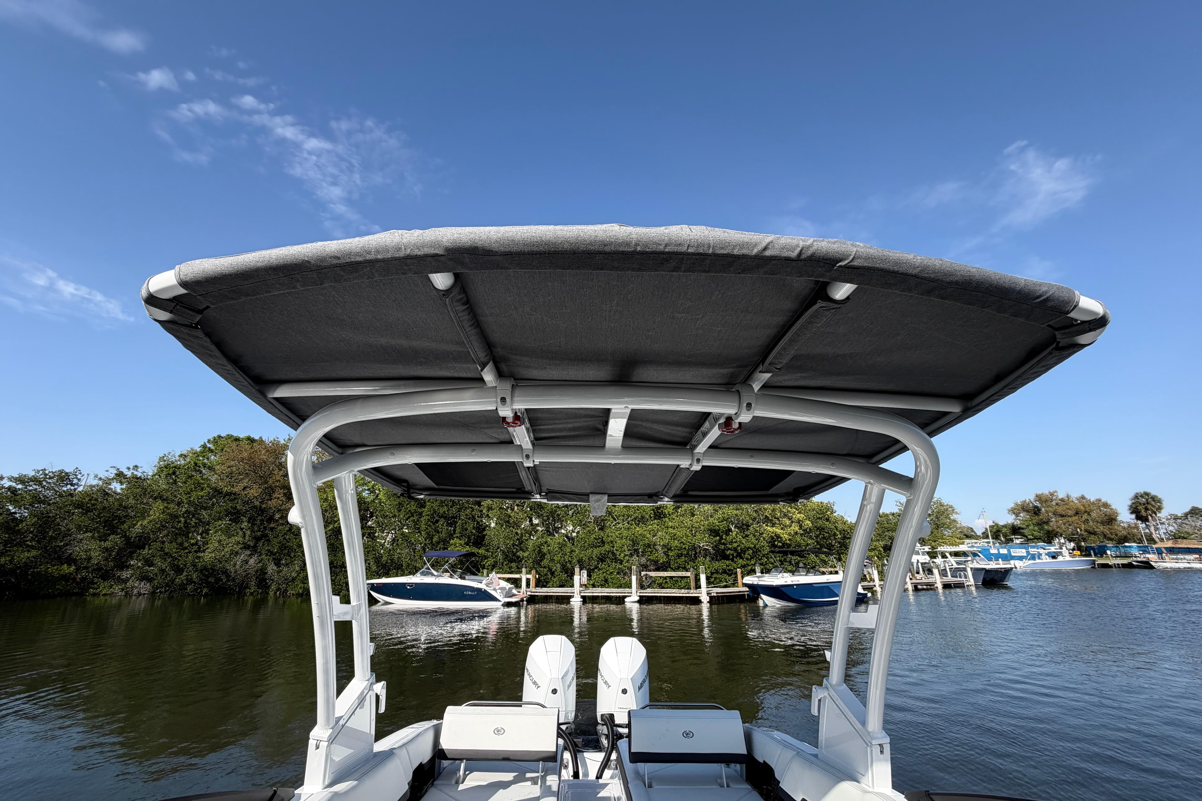 2026 Cobalt R8 Outboard boat with canopy, docked on a sunny day.