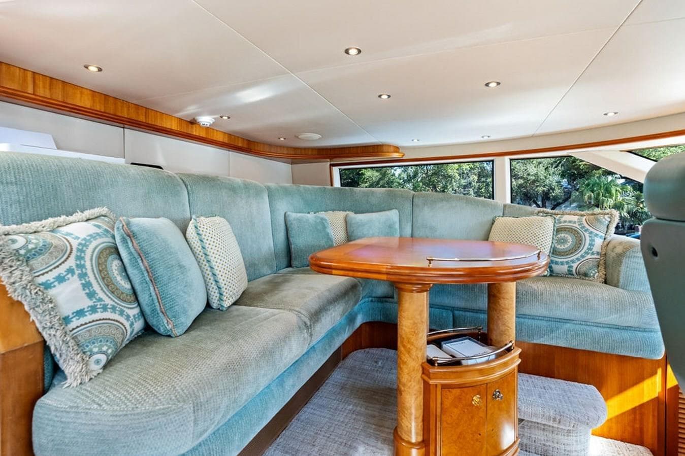 Luxurious 2001 West Bay Sonship yacht interior with plush seating and elegant wooden table.