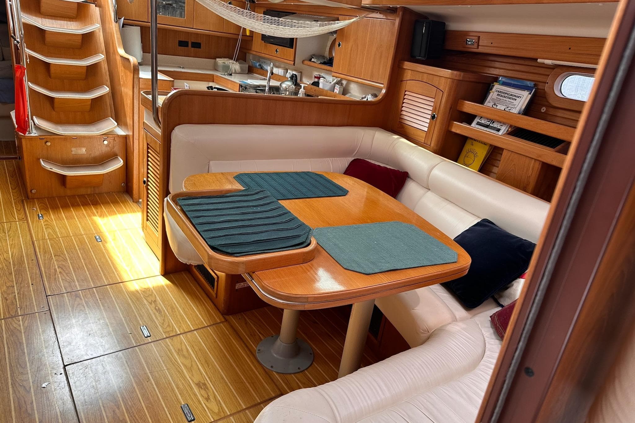 Interior of 2002 Catalina 470 yacht with wooden flooring and cozy dining area.