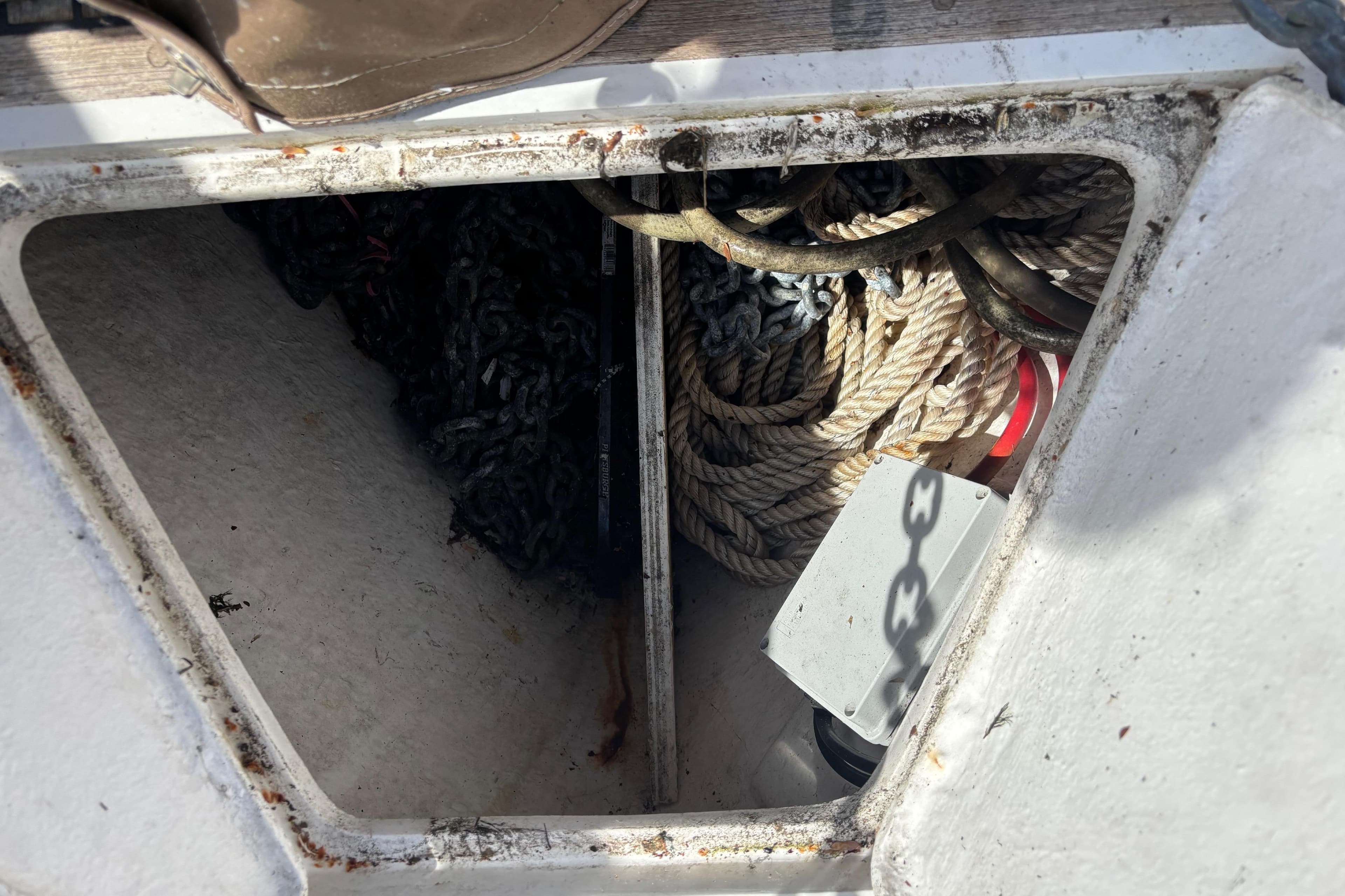 Anchor locker of a 2001 Nauticat Ketch with ropes and chains.