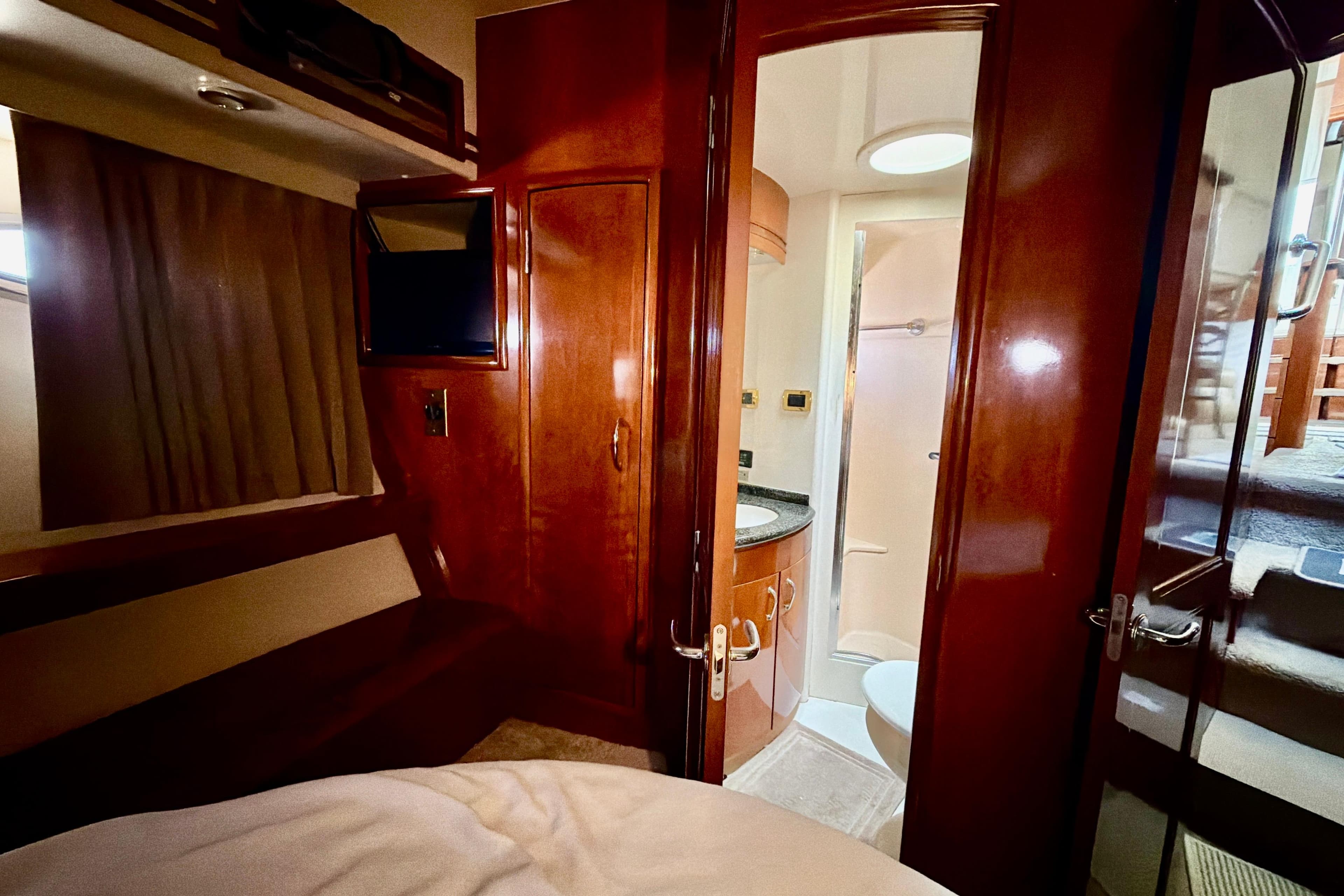 Interior of 2003 Carver 564 Cockpit Motor Yacht with wood finishes and compact bathroom.