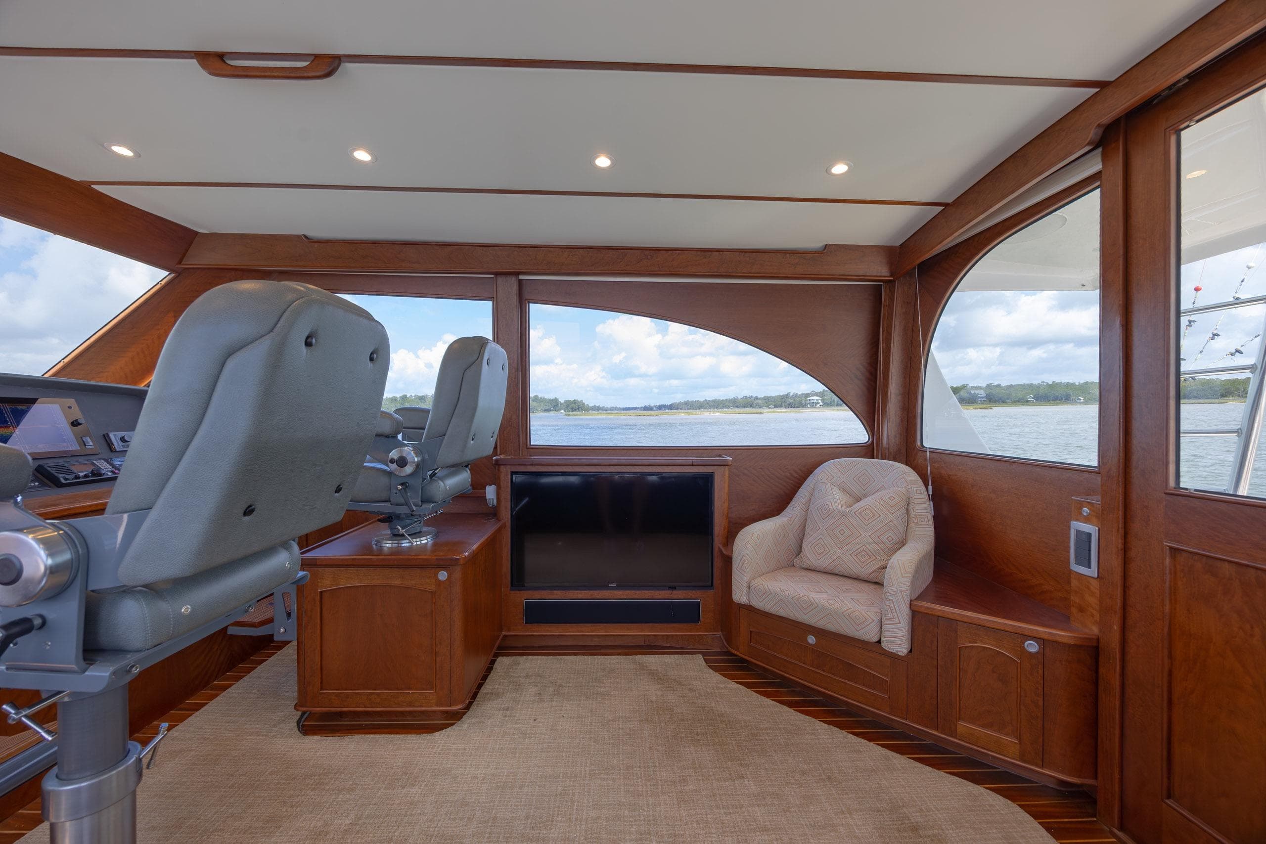2015 Jarrett Bay Hardtop Express Sportfish interior with helm chairs and scenic windows.