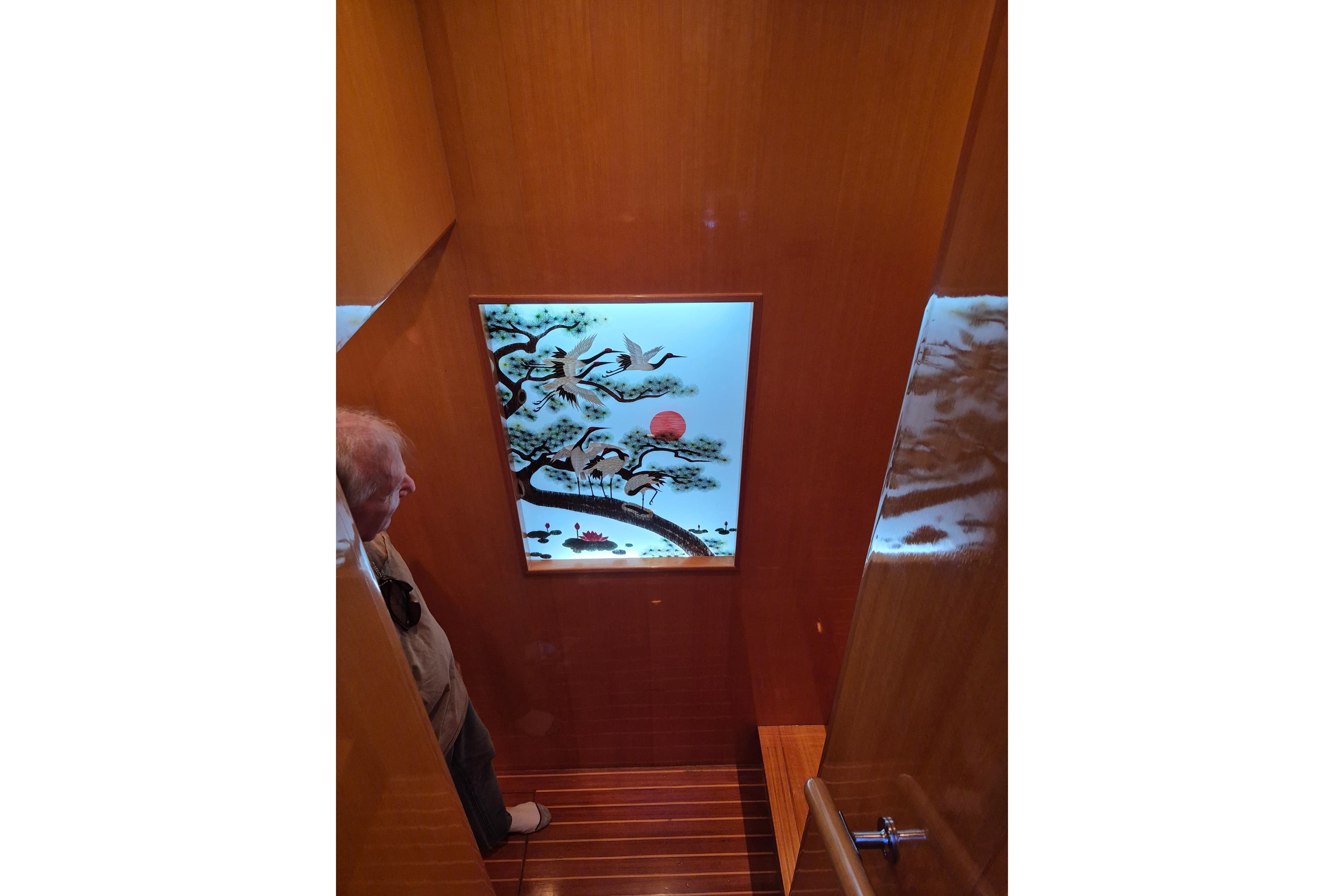 Interior of 2006 Altima Flybridge yacht with decorative wall art and wooden staircase.