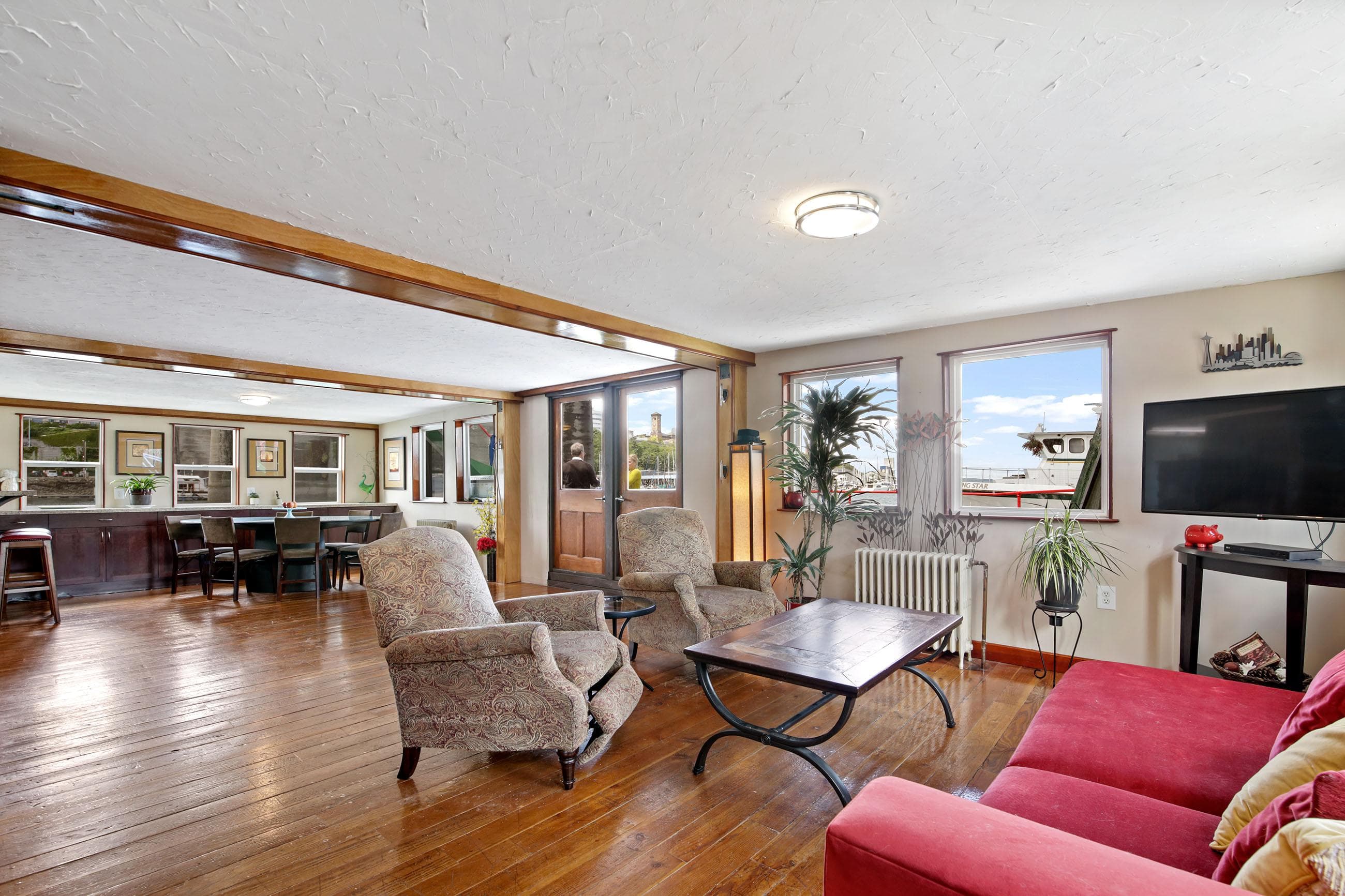Spacious living area on a 1938 custom ferry with modern furnishings and wooden flooring.