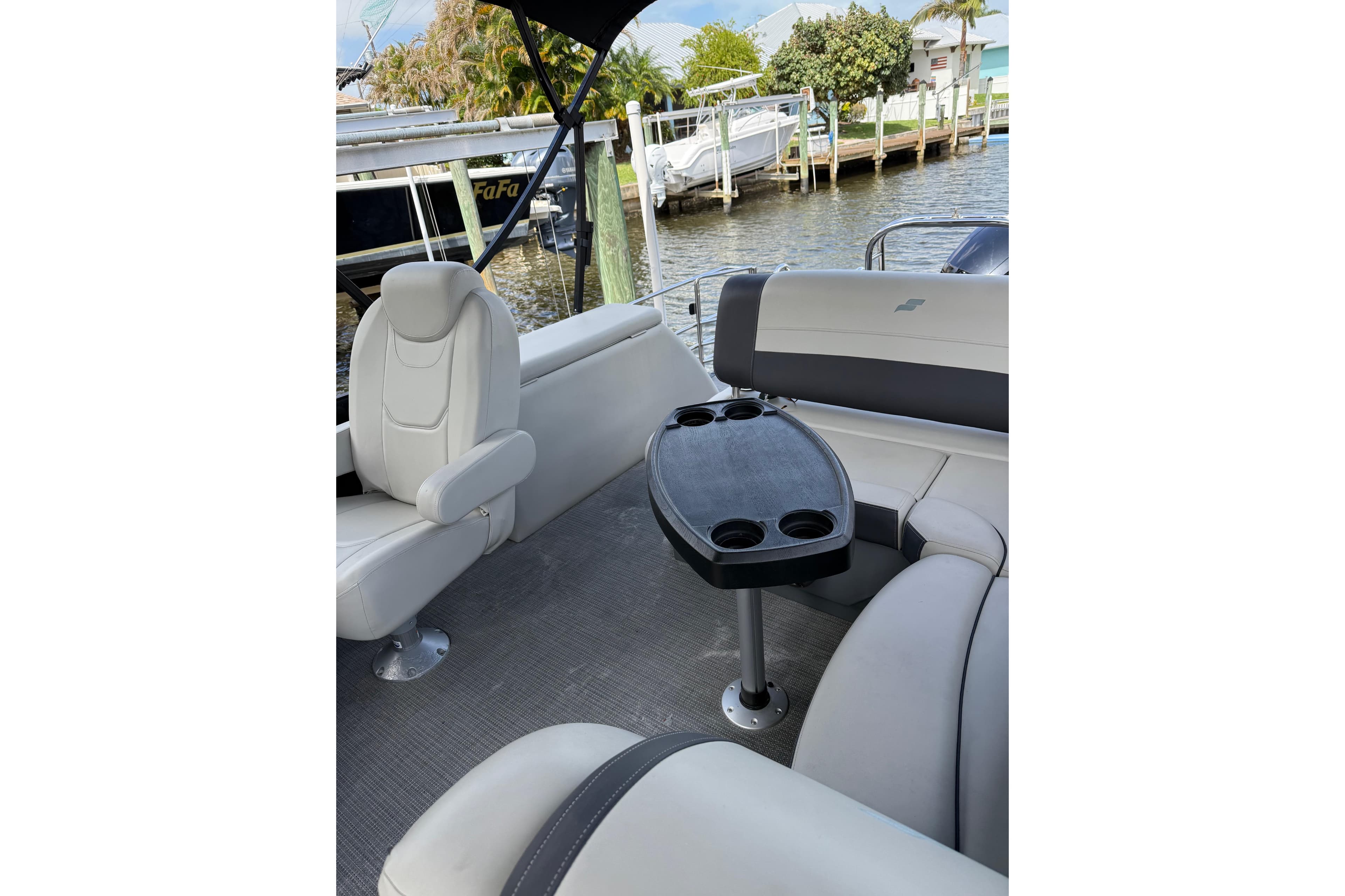 2023 Starcraft EXS 3 Q boat interior with seating and table, docked by the water.