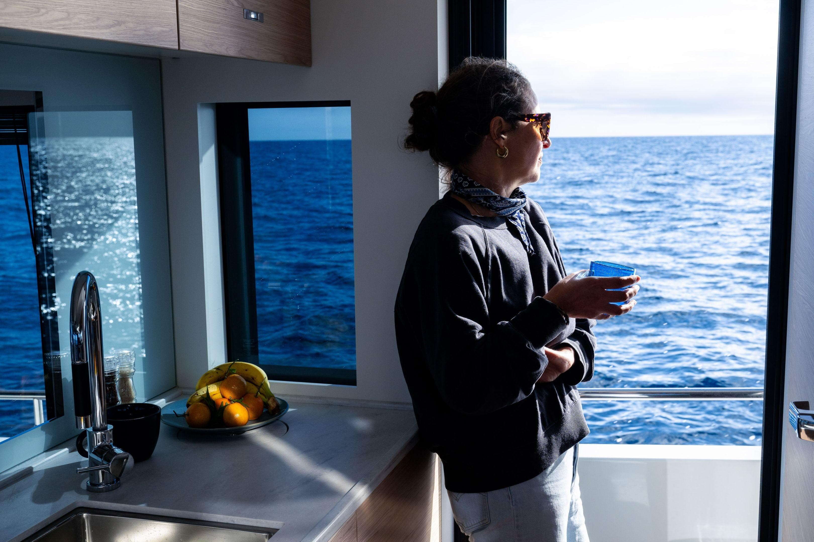 Woman enjoying ocean view from 2026 Beneteau Swift Trawler 54 kitchen.