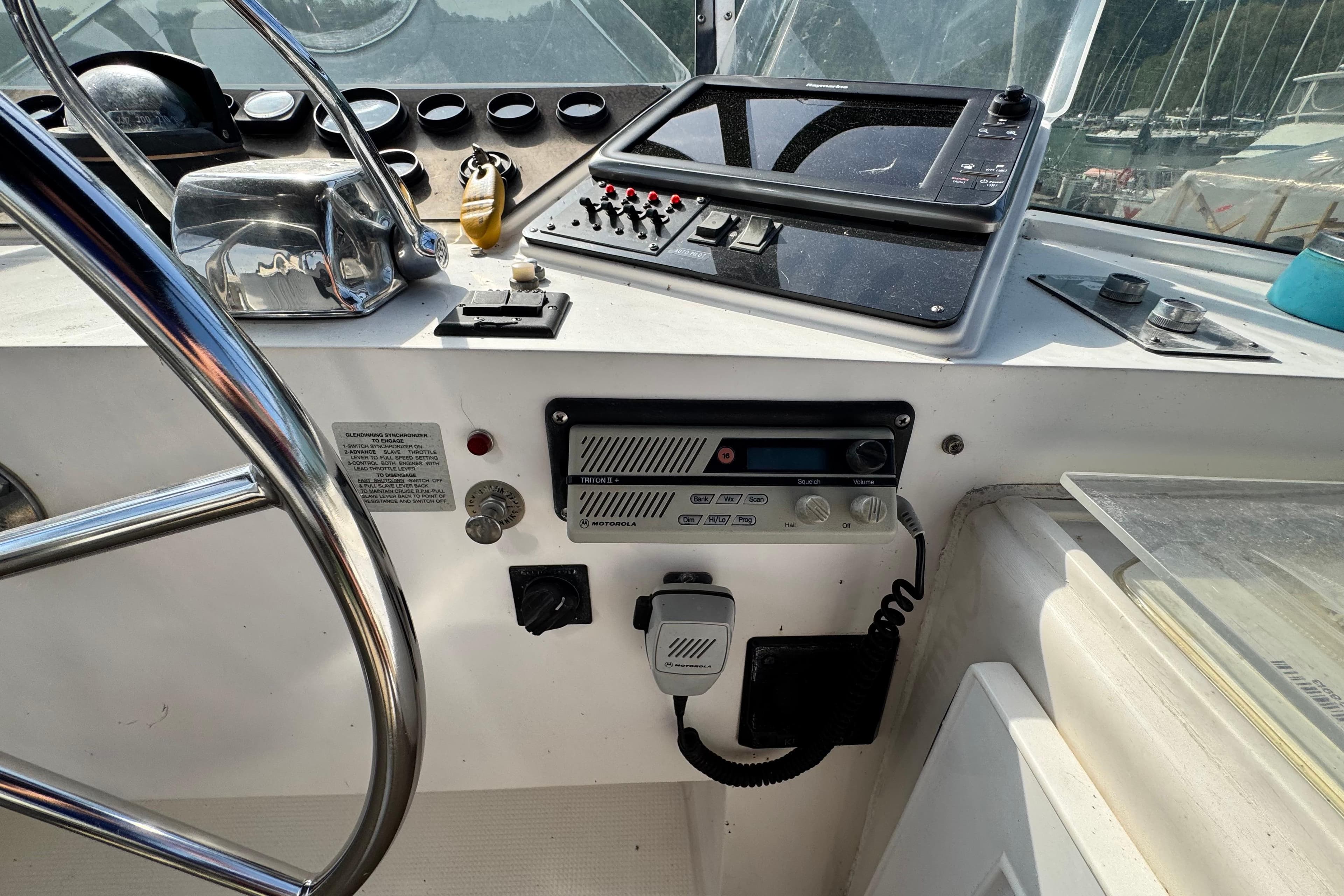 Control panel of a 1989 Hi-Star 42 Sundeck boat with steering wheel and navigation equipment.