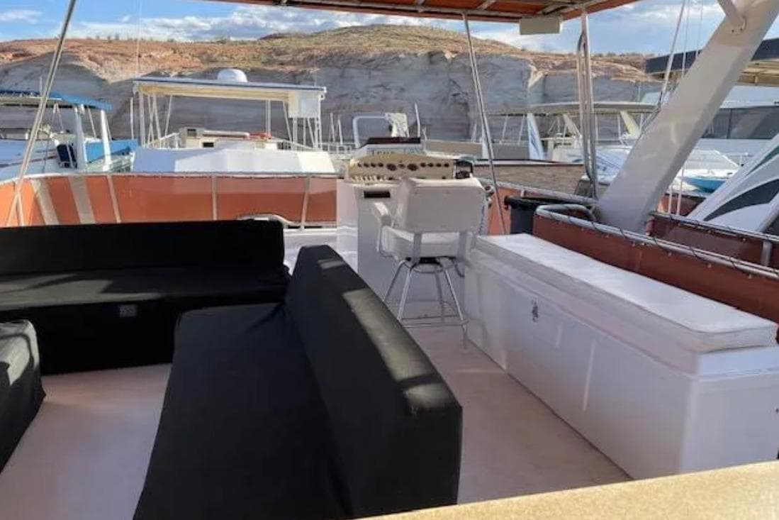 Upper deck of 2007 American Waterways Sundancer, featuring seating and helm, docked at marina.